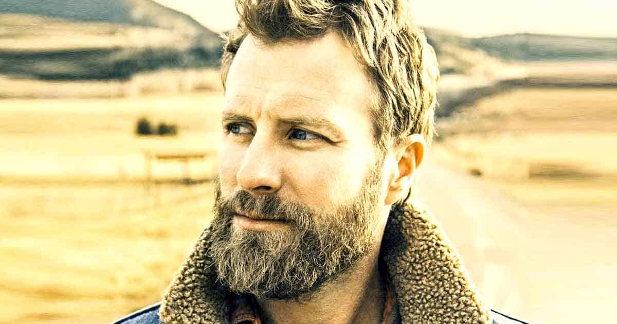Dierks Bentley holding his guitar as he poses before the camera.