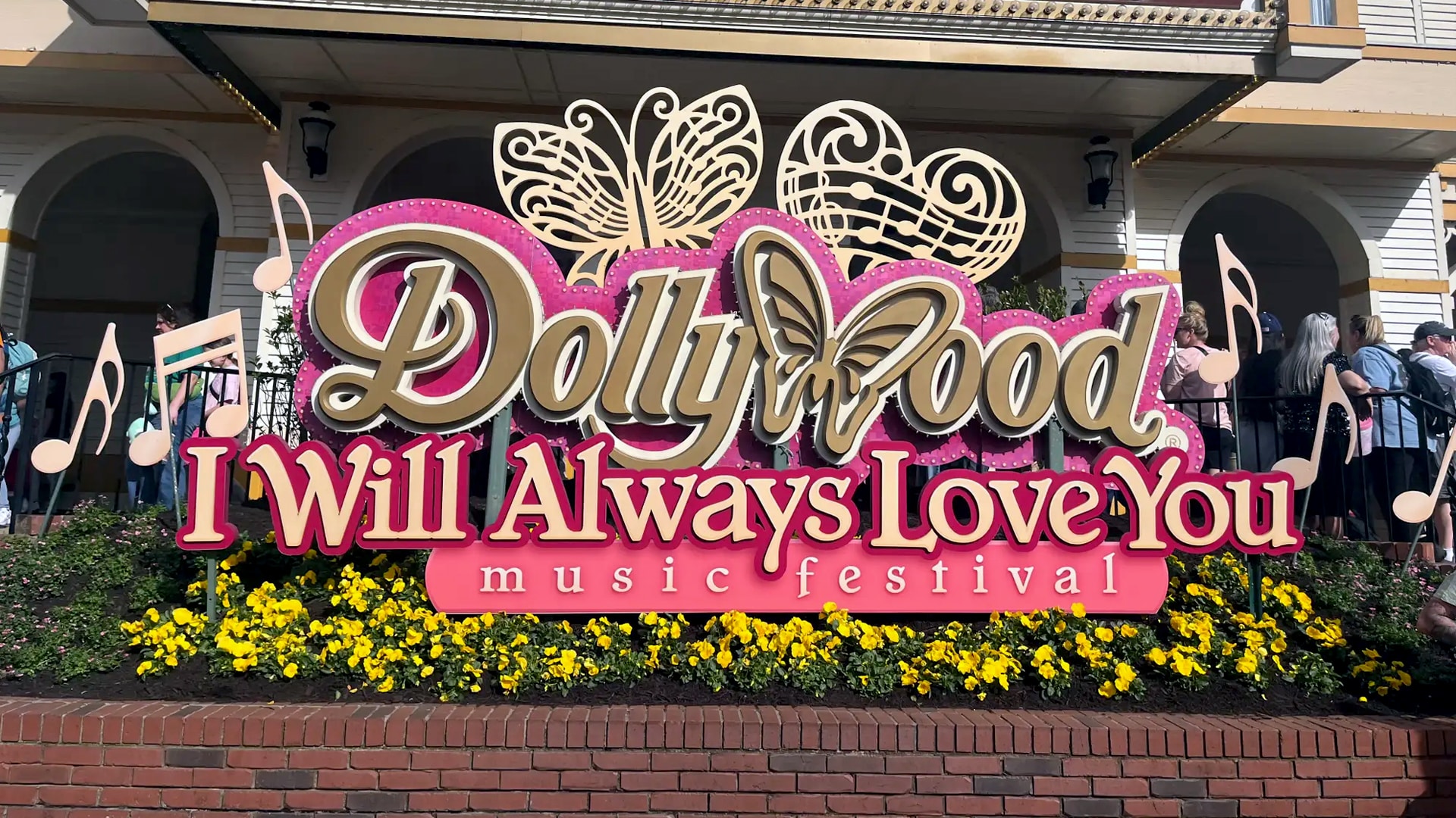Theme park expert Megan DuBois smiles at Dollywood's entrance, surrounded by Smoky Mountain charm after more than 100 visits to Disney.
