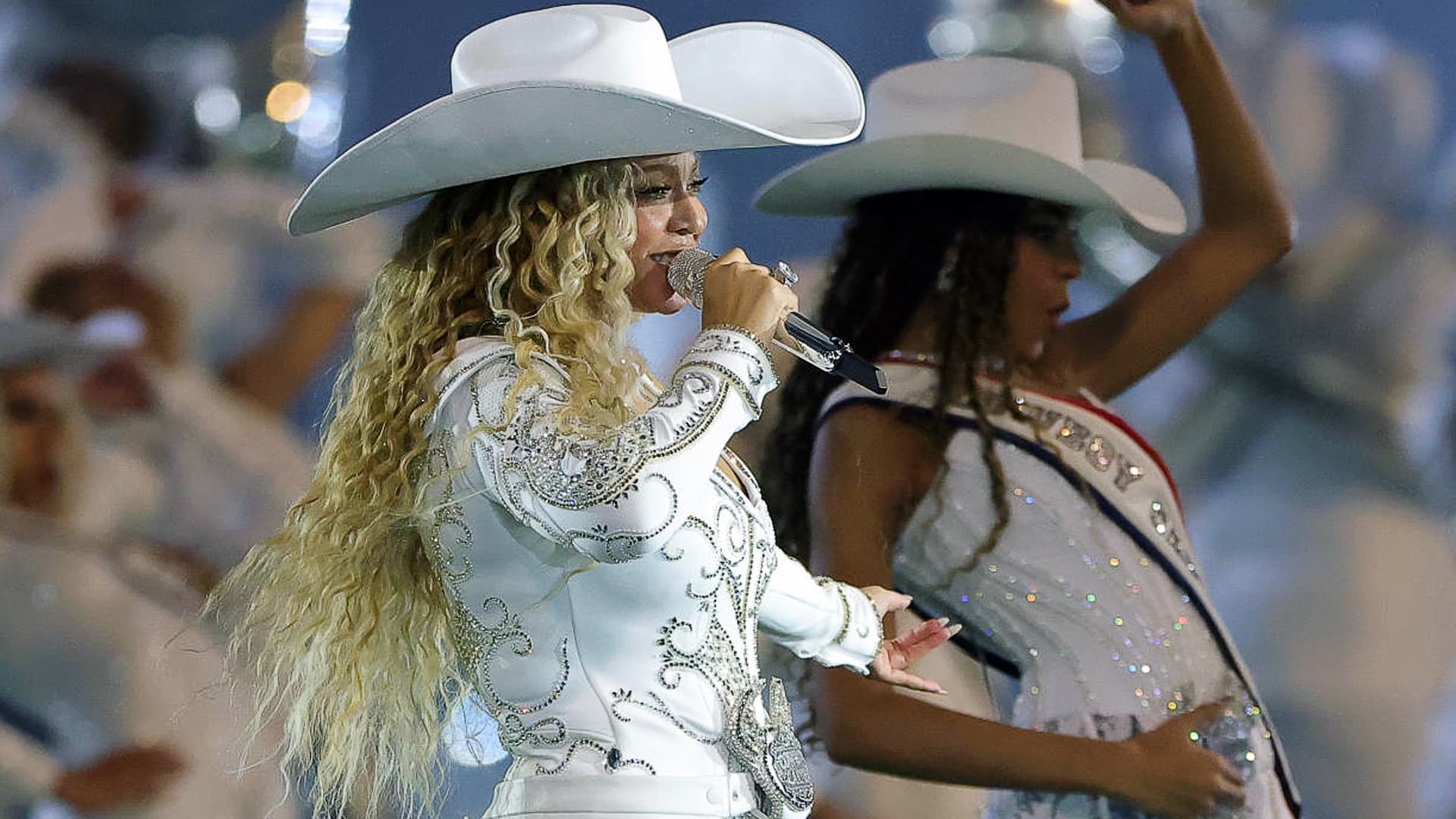 Beyoncé performs in a rhinestone-studded Western outfit during her Cowboy Carter Tour, as reports of empty stadium seats spark debate among traditional country fans.