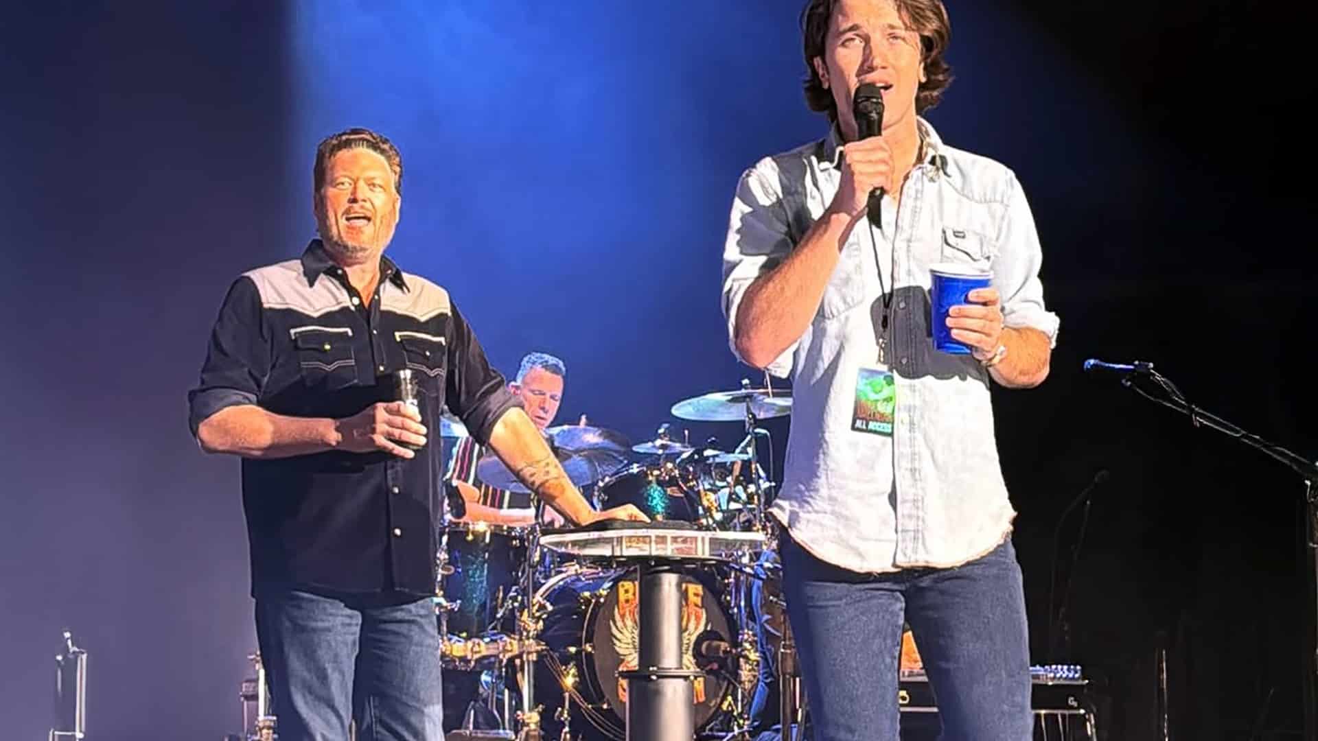 Blake Shelton and Drake Milligan share the stage mid-performance, smiling as they sing George Strait's "All My Ex's Live in Texas" together in Indiana.