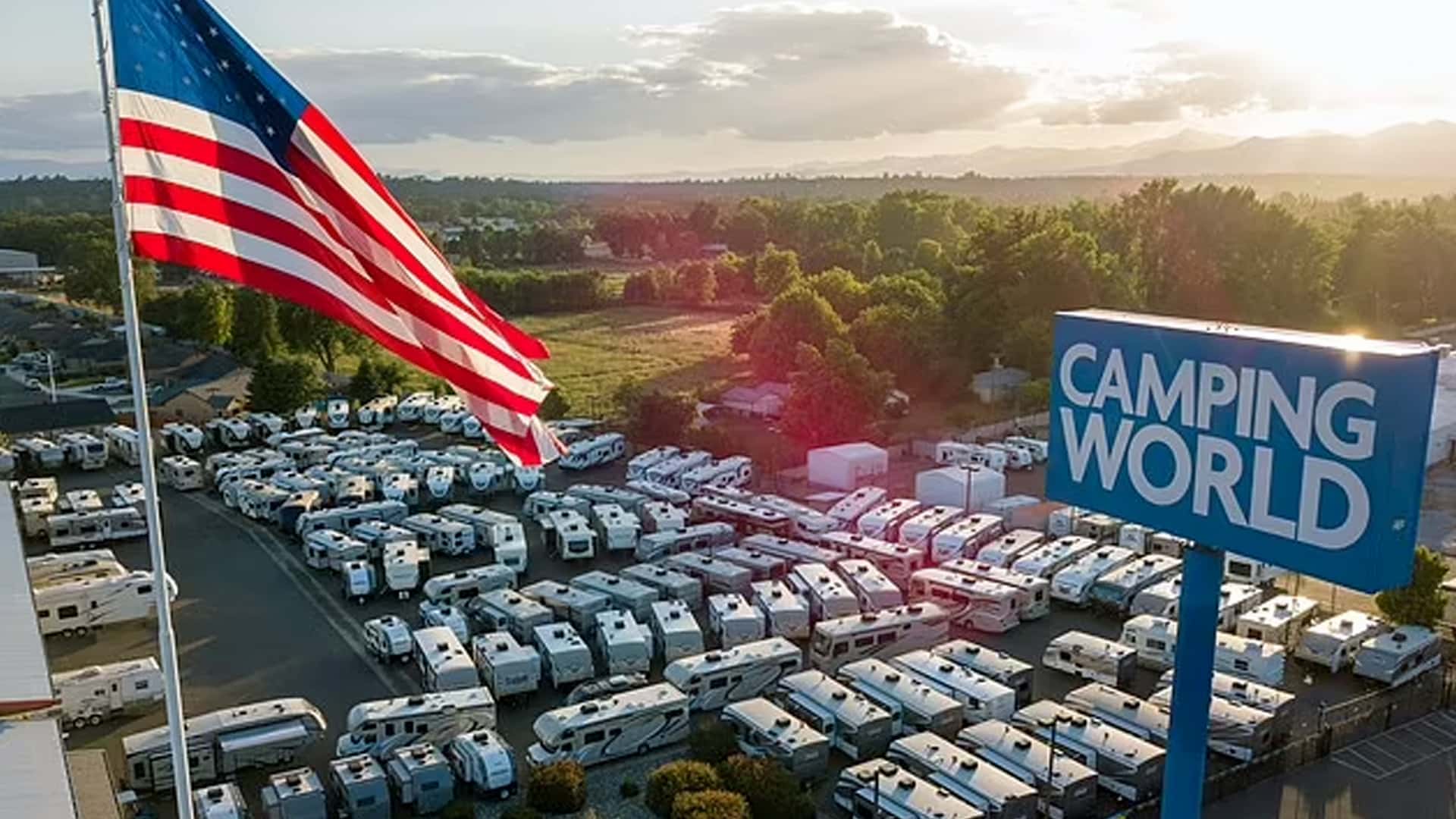 Camping World CEO Marcus Lemonis stands firm beside a 130-foot American flag in Sevierville, Tennessee, refusing to remove it despite a city lawsuit.