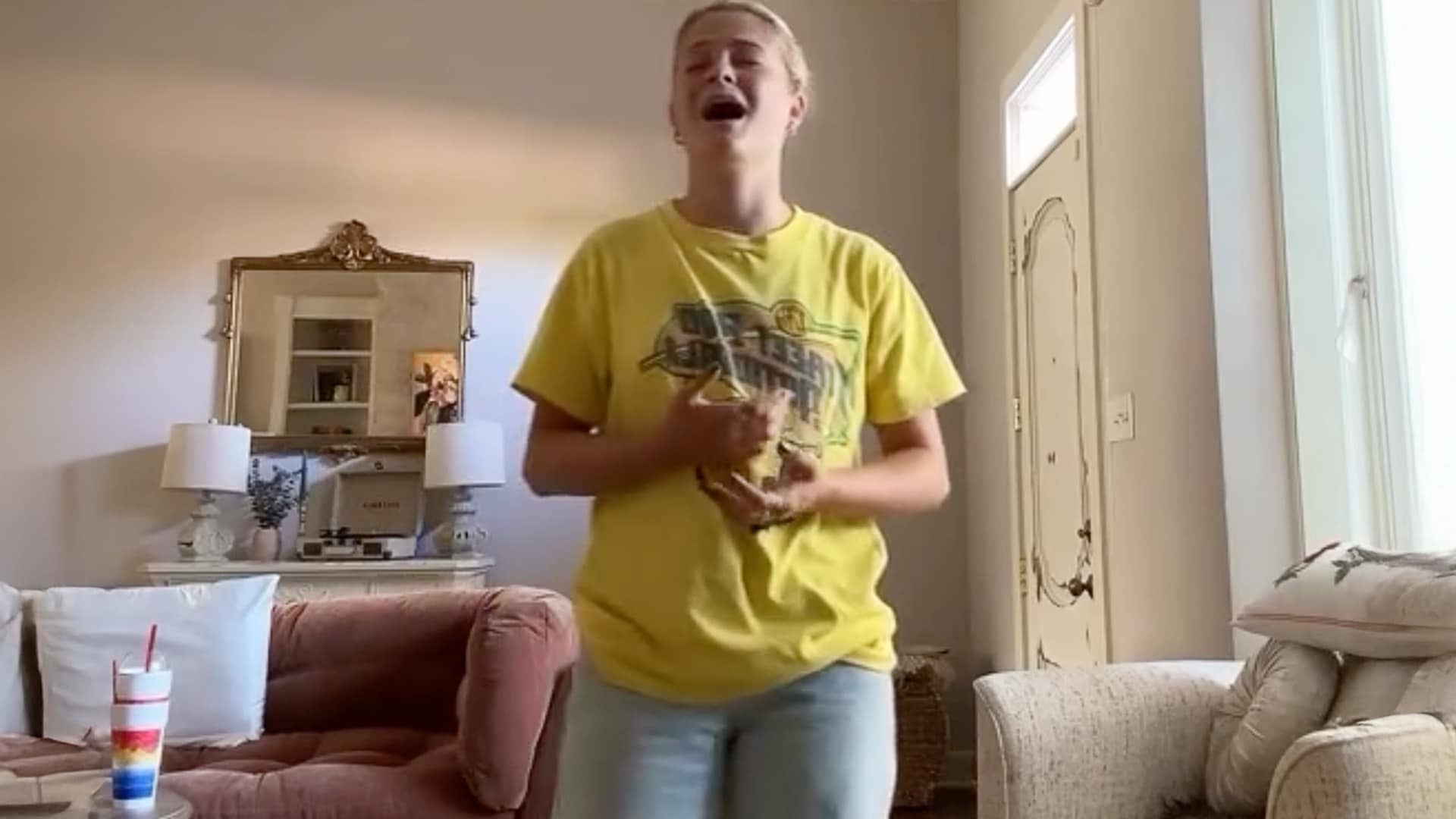 Darci Lynne sings passionately in her living room wearing a yellow shirt and jeans, delivering a raw a cappella cover of Lainey Wilson's "Sunday Best."