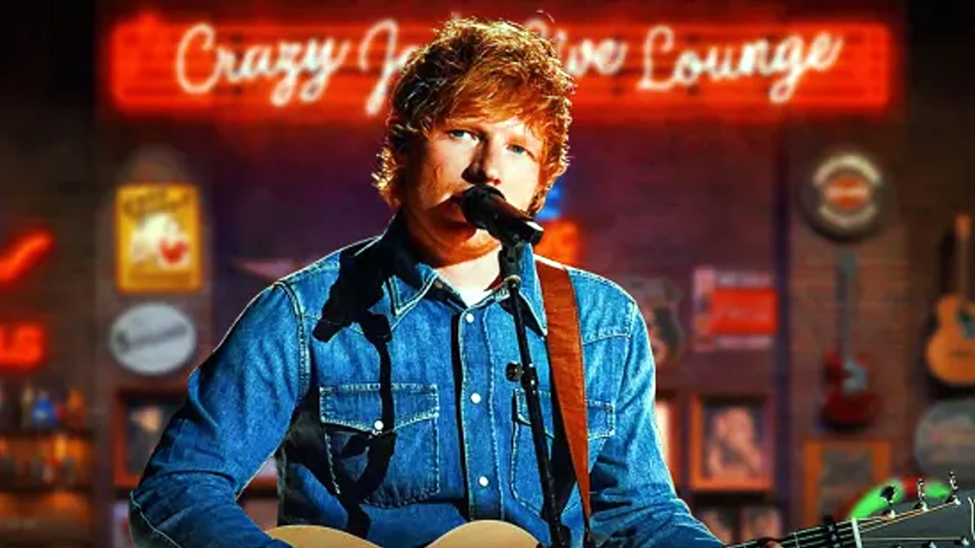 Ed Sheeran performing in denim with a guitar under neon lights, keeping it real without a fake country accent.