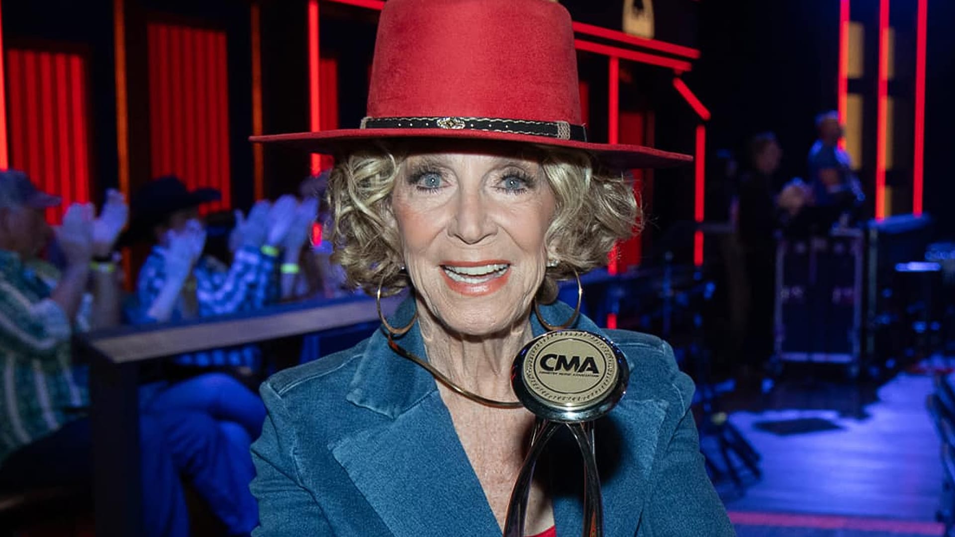 Jeannie Seely proudly holds her CMA award, celebrating her triumph with "Don't Touch Me"—a hit she nearly lost to more connected country stars.