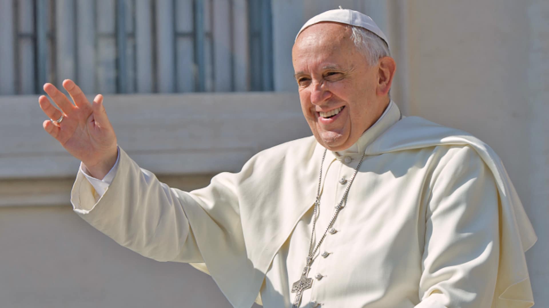 Pope Francis smiles and waves in his traditional white robes during one of his final public appearances before his passing at age 88.