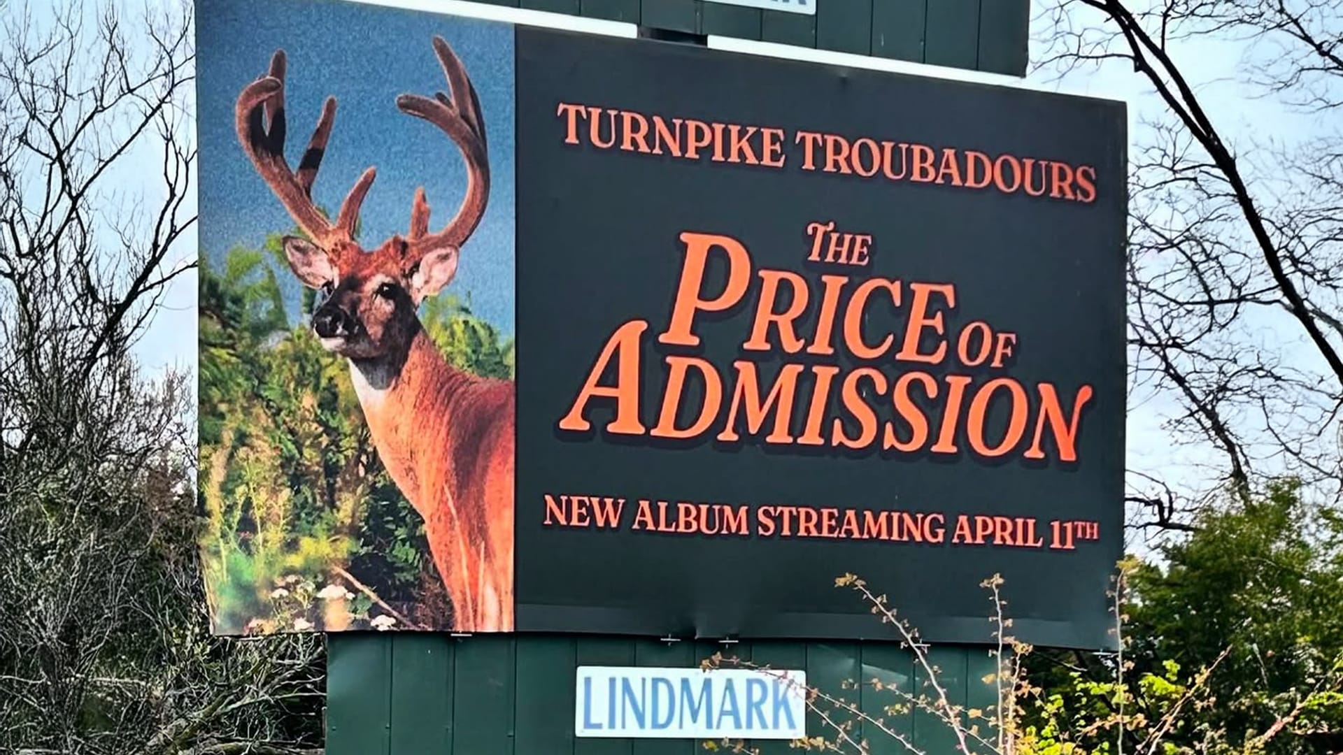 A mysterious roadside billboard in Stillwater teasing Turnpike Troubadours' rumored new album, surrounded by rural scenery and sparking fan speculation.