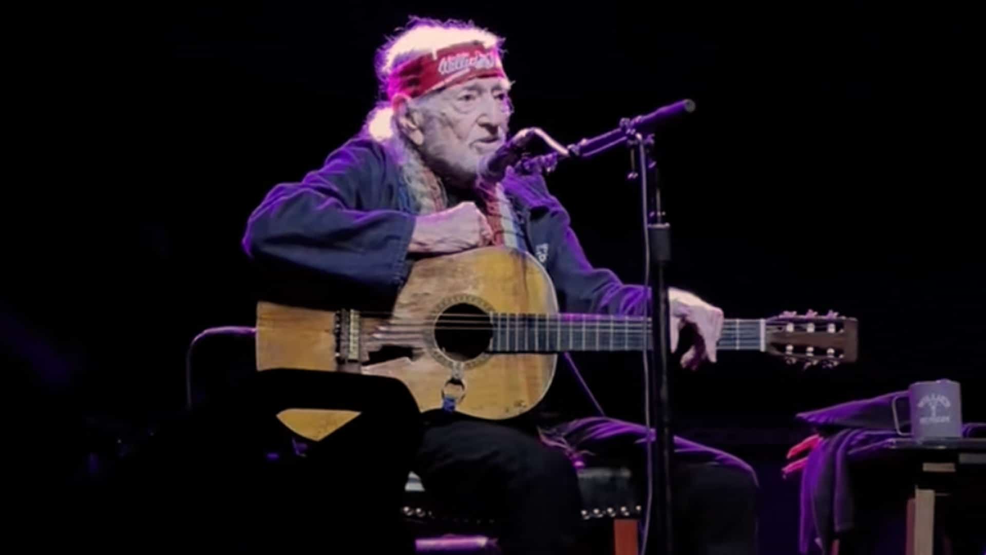 Willie Nelson performs “Georgia on My Mind” live in Macon, Georgia, at age 91, seated with his iconic guitar and red bandana as the crowd rises in reverent applause.