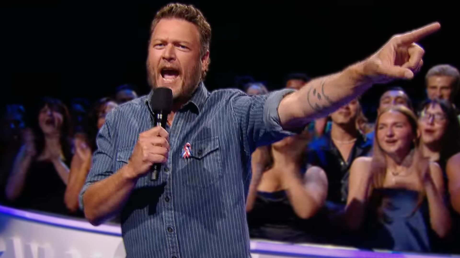 Blake Shelton points to the crowd during his fiery AMAs debut with "Stay Country or Die Tryin’."