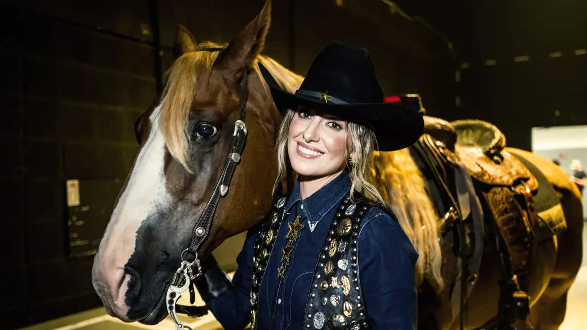 Lainey Wilson poses with a horse in a star-studded outfit, capturing the same down-home authenticity and bold flair that earned her Entertainer of the Year at the 2025 ACM Awards.