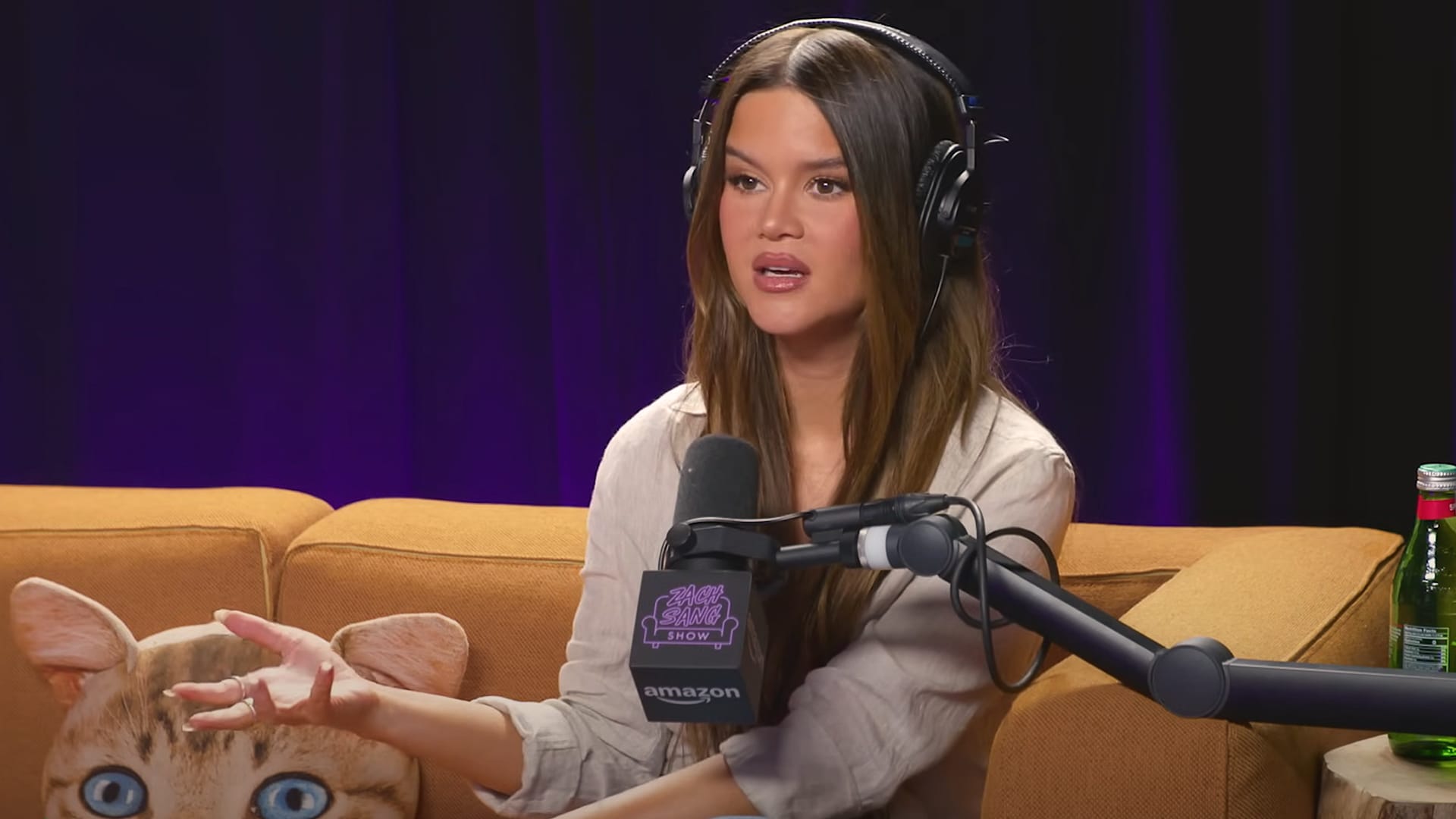 Maren Morris speaks passionately into a podcast mic, comparing her career to legends like Johnny Cash and Kris Kristofferson, sparking debate about legacy and authenticity.