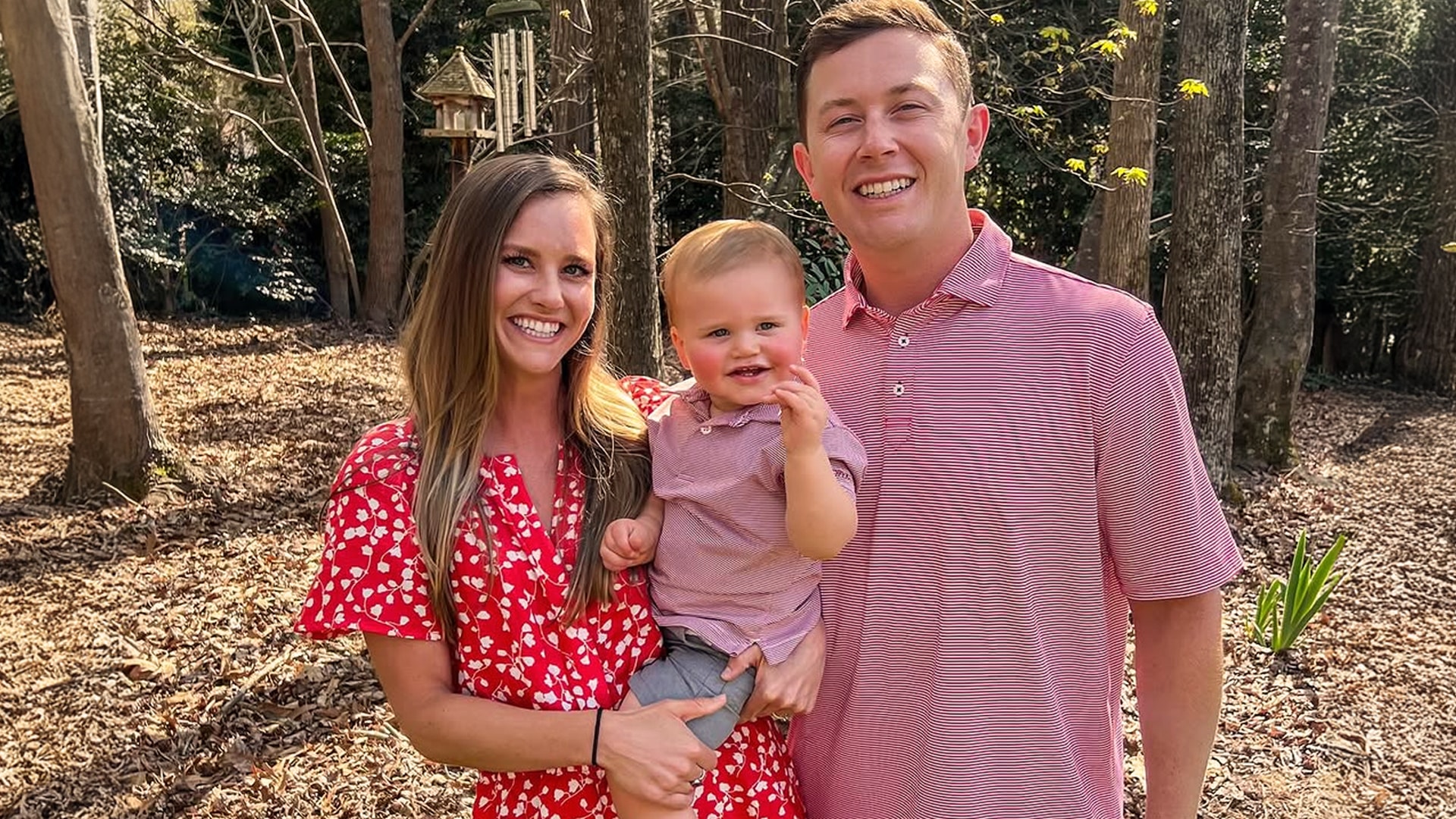 Scotty McCreery and wife Gabi pose outdoors with their toddler son as they celebrate their second baby on the way.