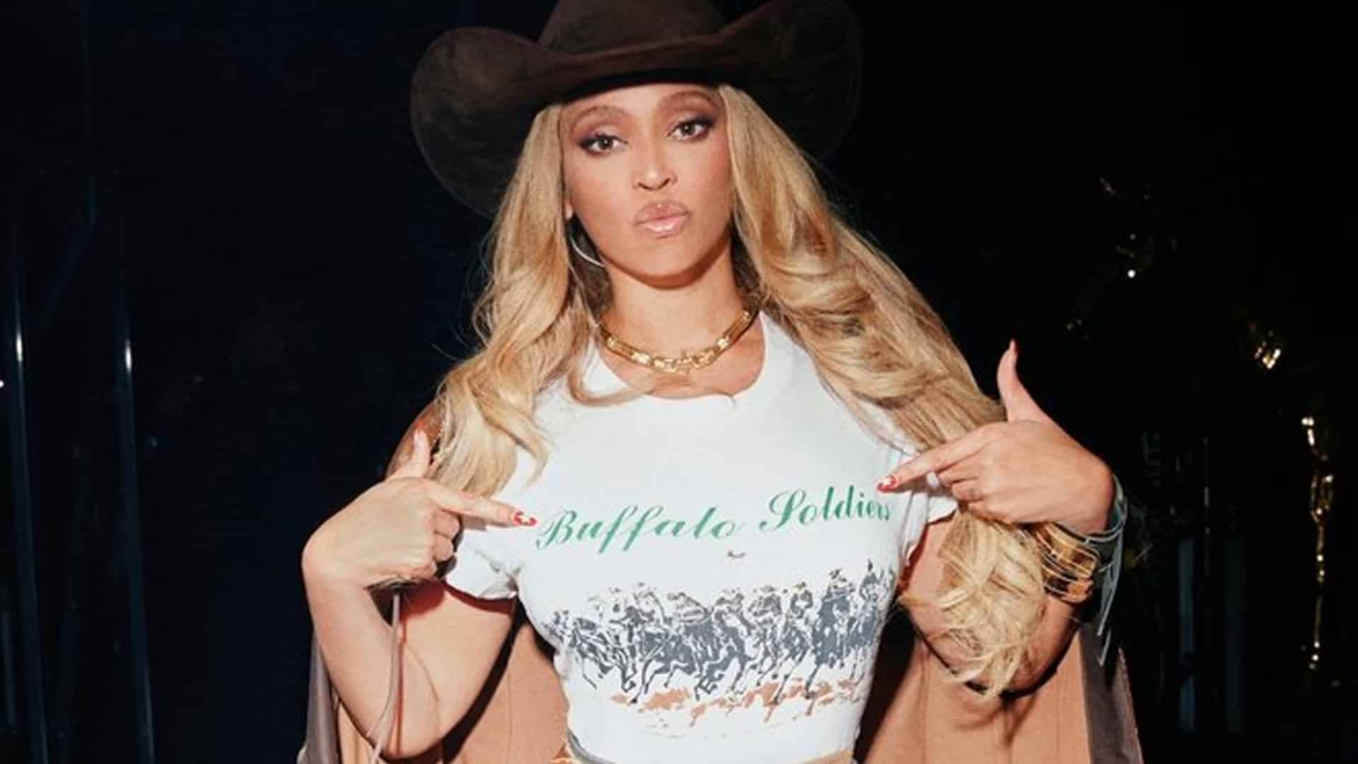 Beyoncé points at her Buffalo Soldiers shirt during her Cowboy Carter tour, the shirt that sparked backlash for its wording.