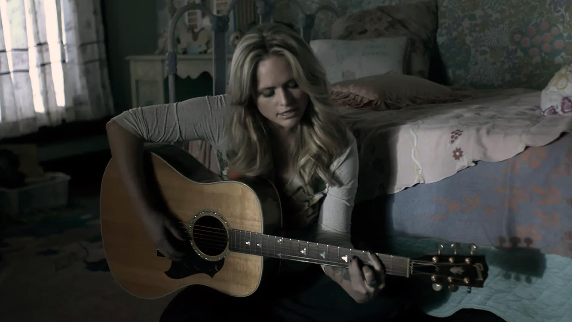 Miranda Lambert plays guitar in a cozy bedroom, the perfect moment that shows how she made “The House That Built Me” a classic.