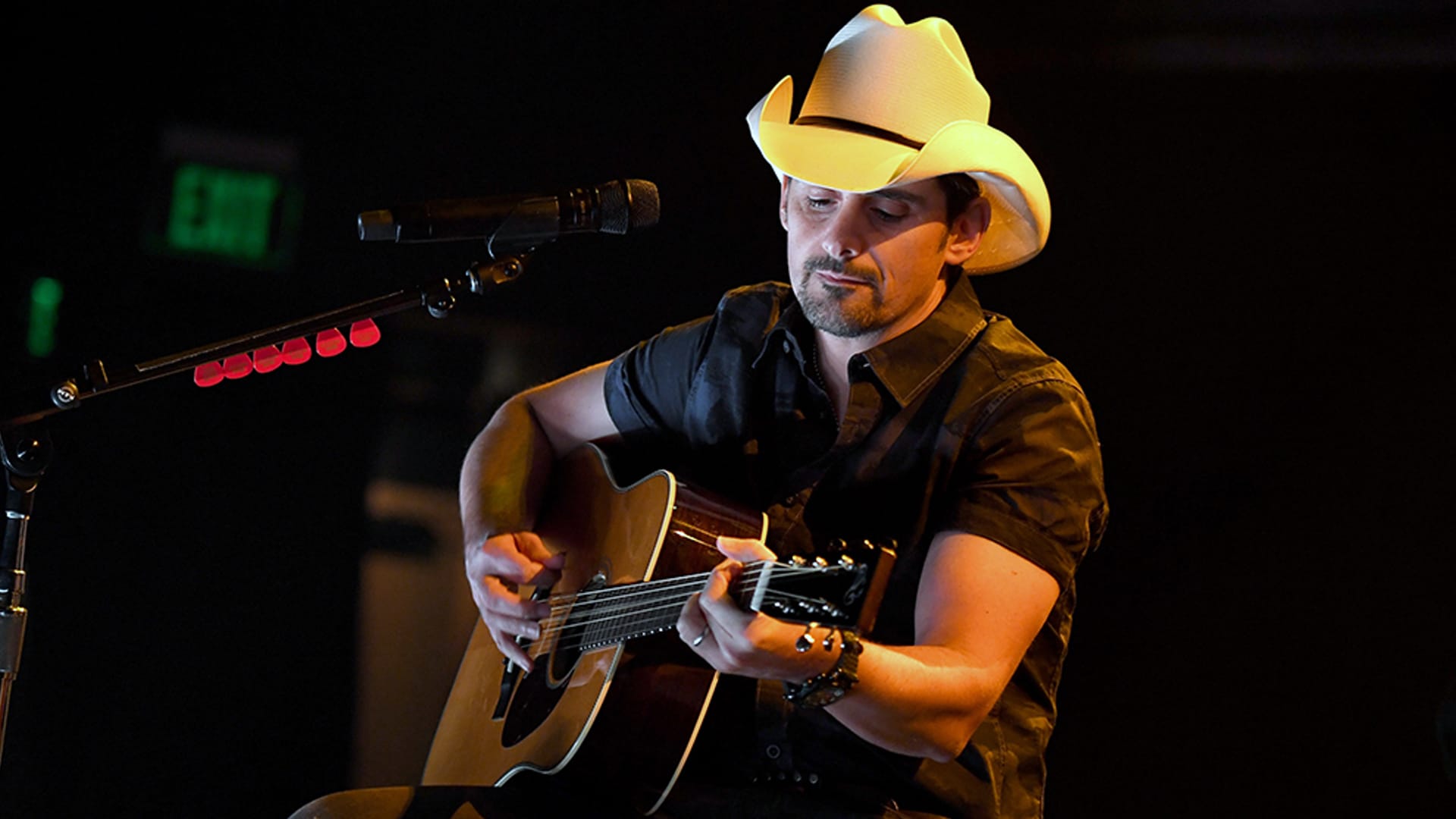 Brad Paisley strums his guitar under a spotlight—looking like he’s about to sing the song that breaks every stepdad’s heart wide open. Not the original performance, but you can feel the same lump in your throat.