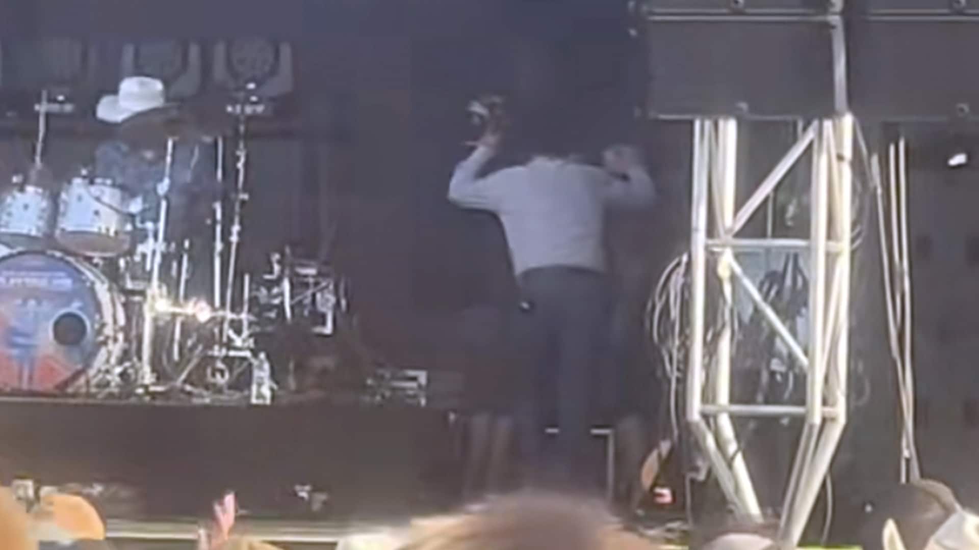 Clay Walker receives help while exiting the stage at Rock the South, showing visible effects of his MS battle.