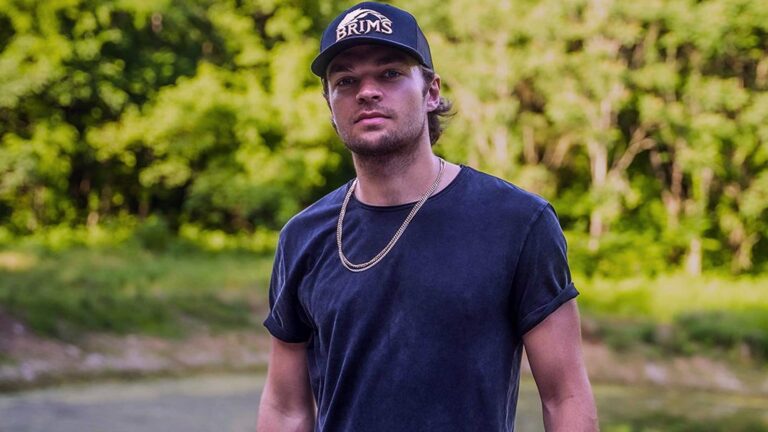 Country singer Conner Smith stands outdoors in casual clothing and a ball cap, as reports surface linking him to a tragic Nashville crosswalk accident that resulted in the death of a 77-year-old woman.
