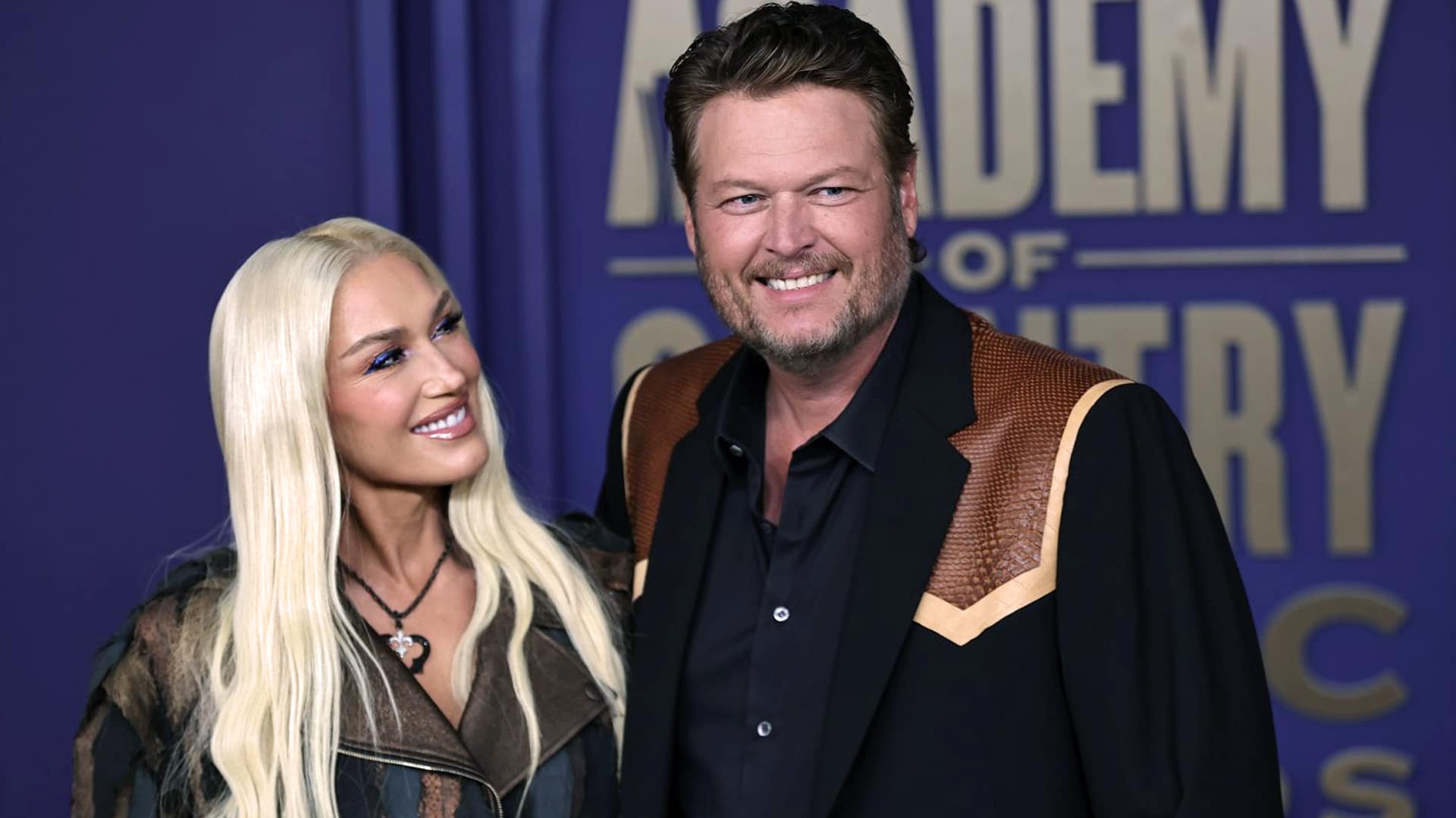 Gwen Stefani smiles at Blake Shelton on the red carpet of the Academy of Country Music Awards—despite new song lyrics fueling speculation about trouble in their marriage.