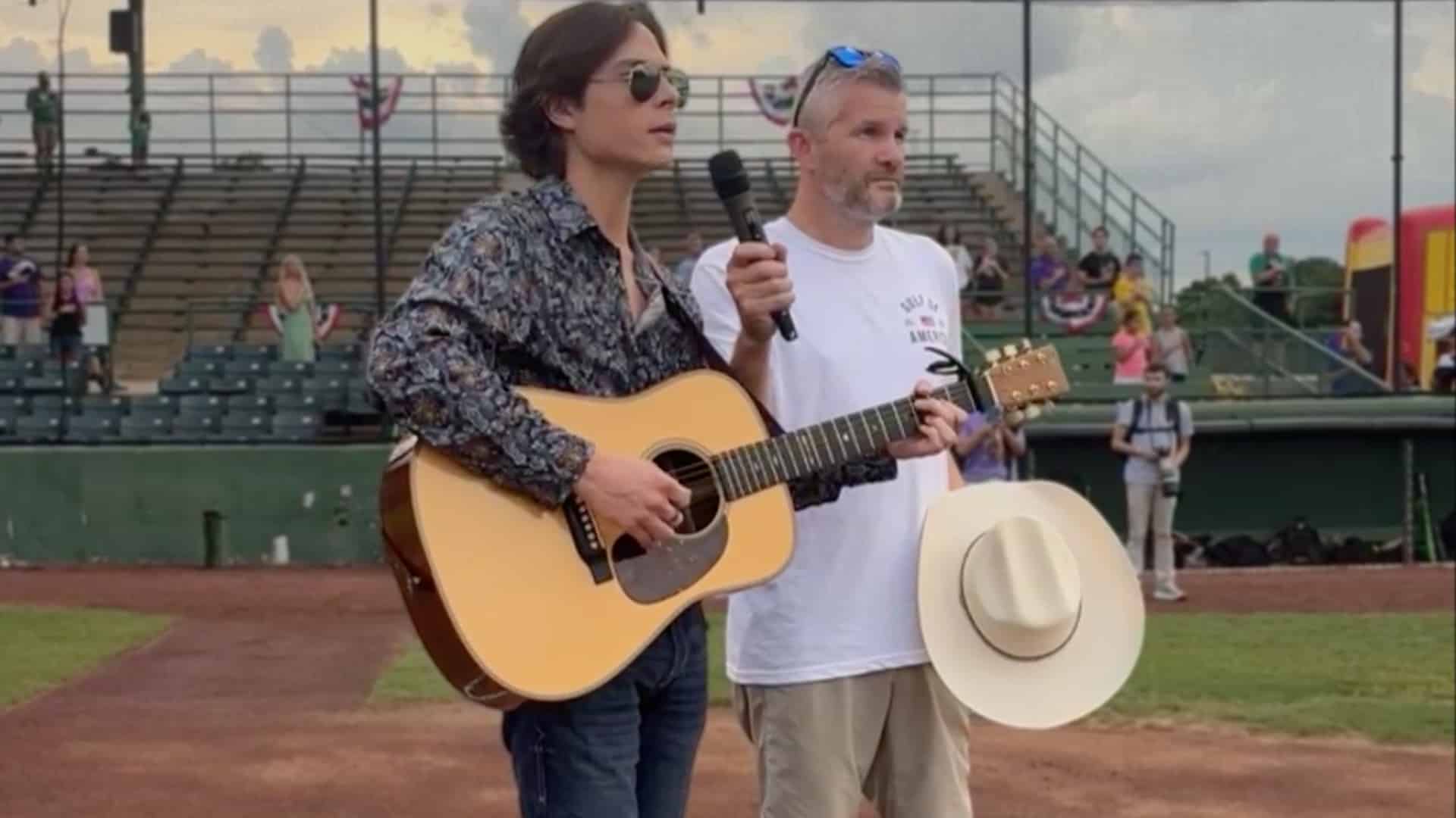 John Foster performs the National Anthem with guitar in hand before throwing the first pitch at a Rougarou game.