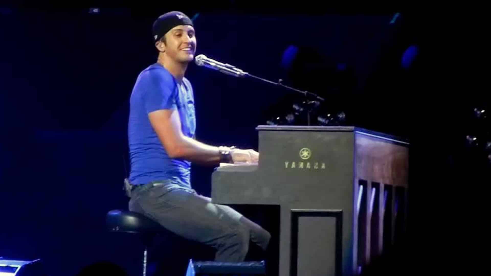 Luke Bryan laughs at the piano during a concert moment, capturing the exact scene where he forgot the lyrics to his own hit “Strip It Down” but charmed the crowd anyway.