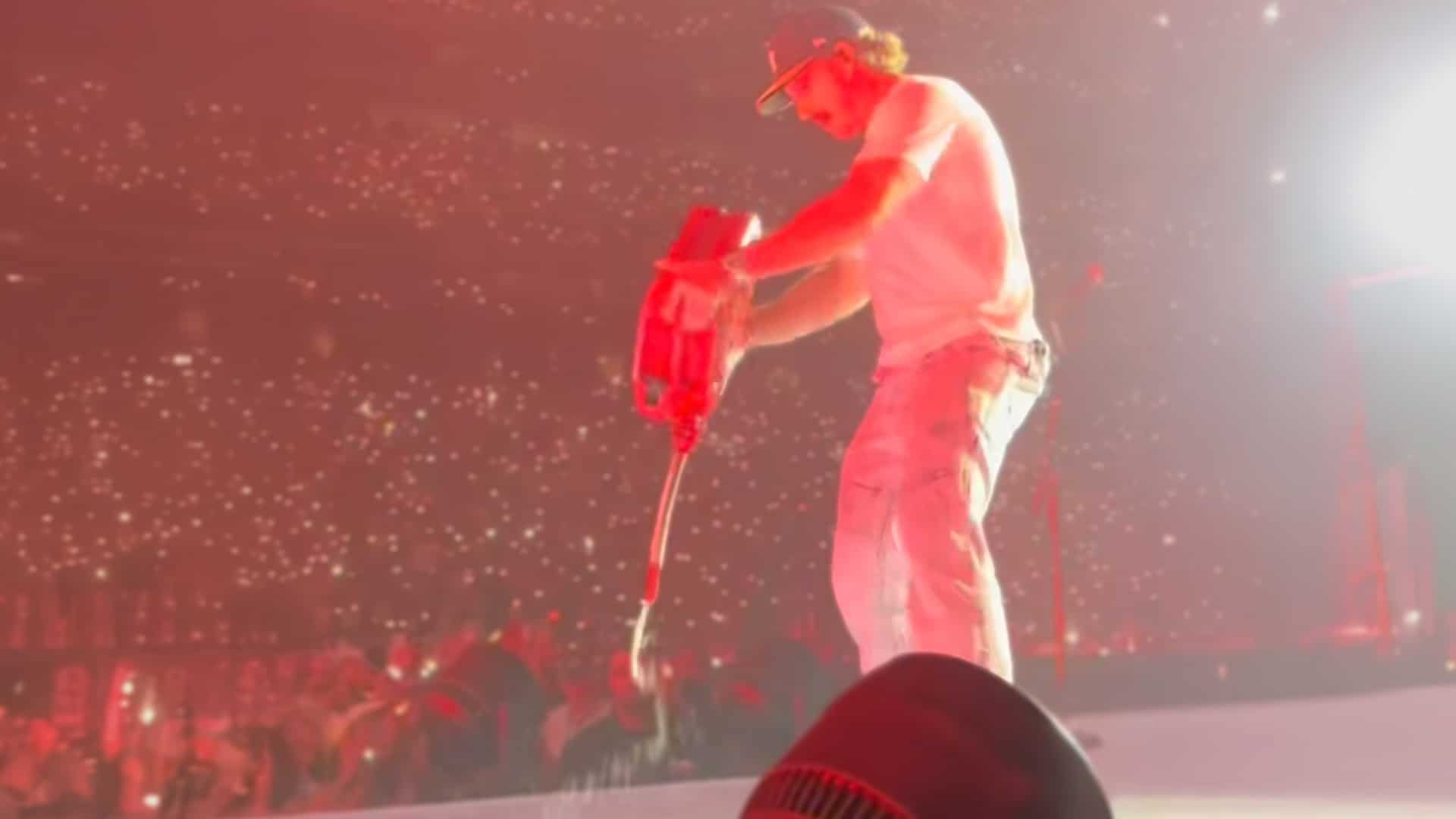 Morgan Wallen pours fake kerosene onstage during his 2025 tour kickoff in Houston, symbolically burning the past behind him.