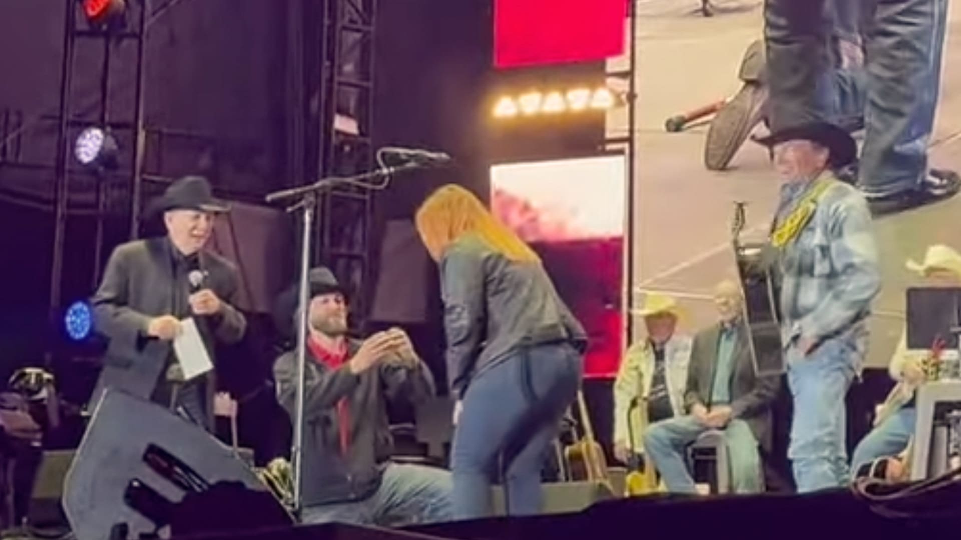 A Purple Heart veteran proposes to his girlfriend onstage moments after George Strait gifts him a new home during a heartfelt concert surprise.
