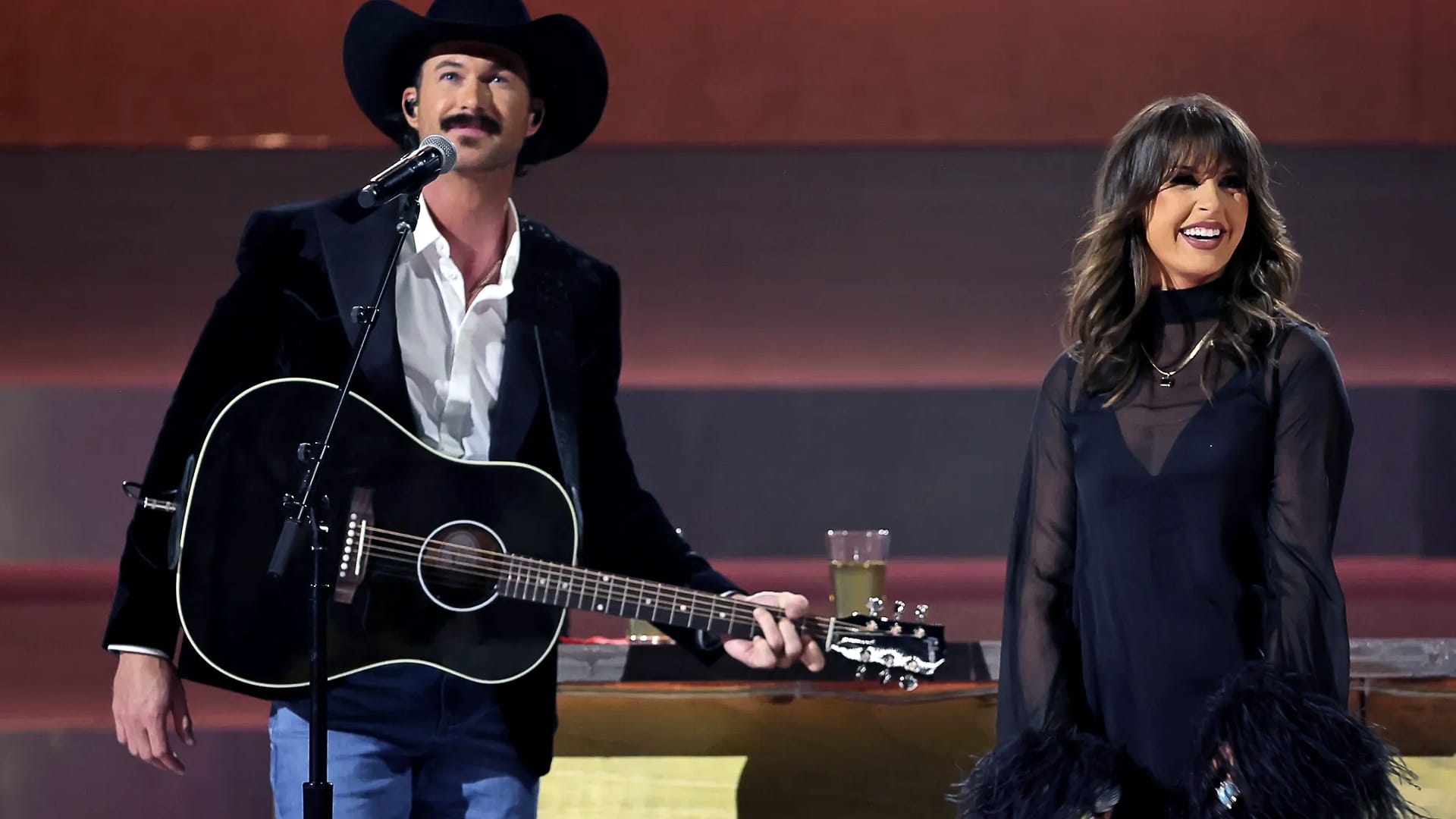 Riley Green and Ella Langley perform onstage, smiling after their duet “You Look Like You Love Me” proved traditional country still hits big.