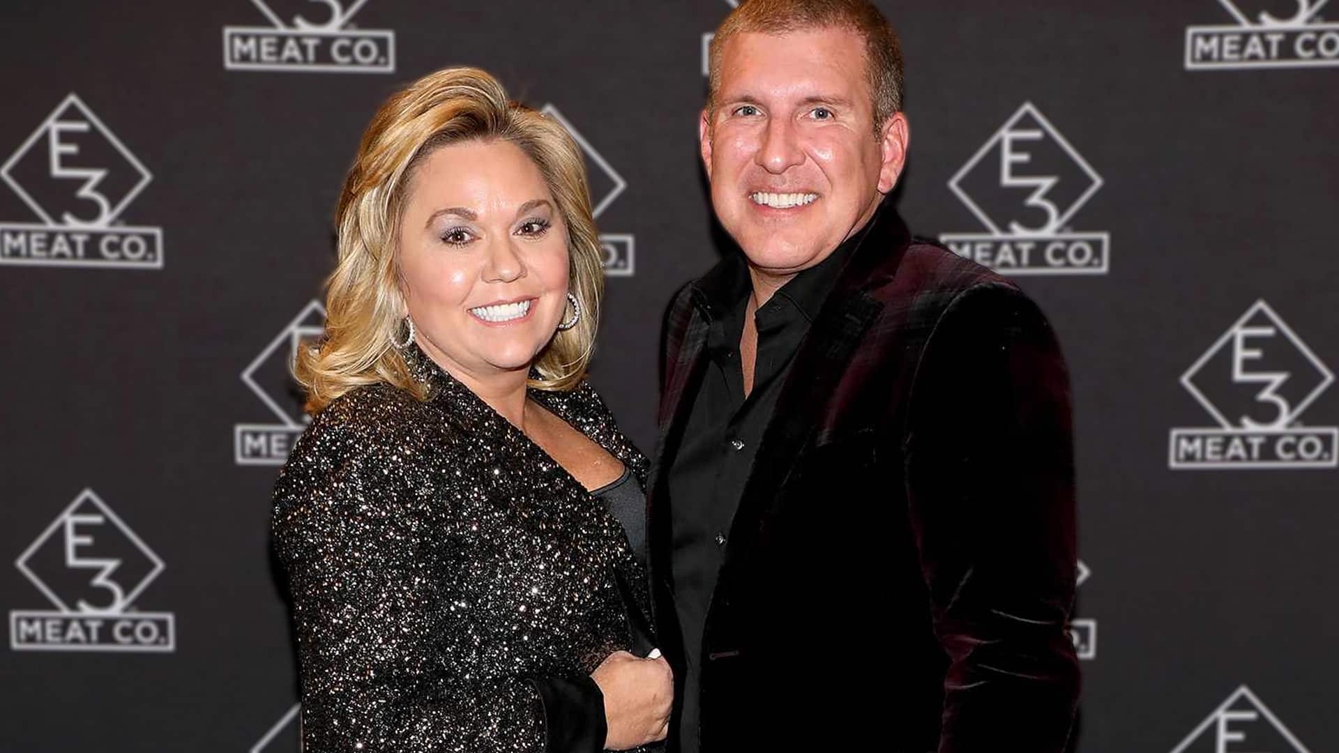 An older photo of Todd and Julie Chrisley smiling at a public event, now resurfacing as they return to reality TV after serving prison time.