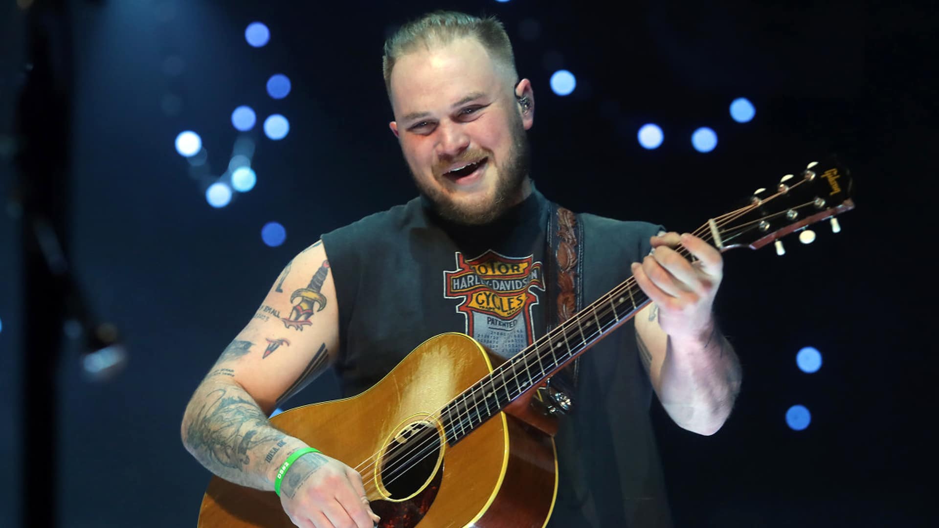 Zach Bryan smiles like a man who just tipped $7,000 after a pint—and made someone’s college dreams come true in Dublin.