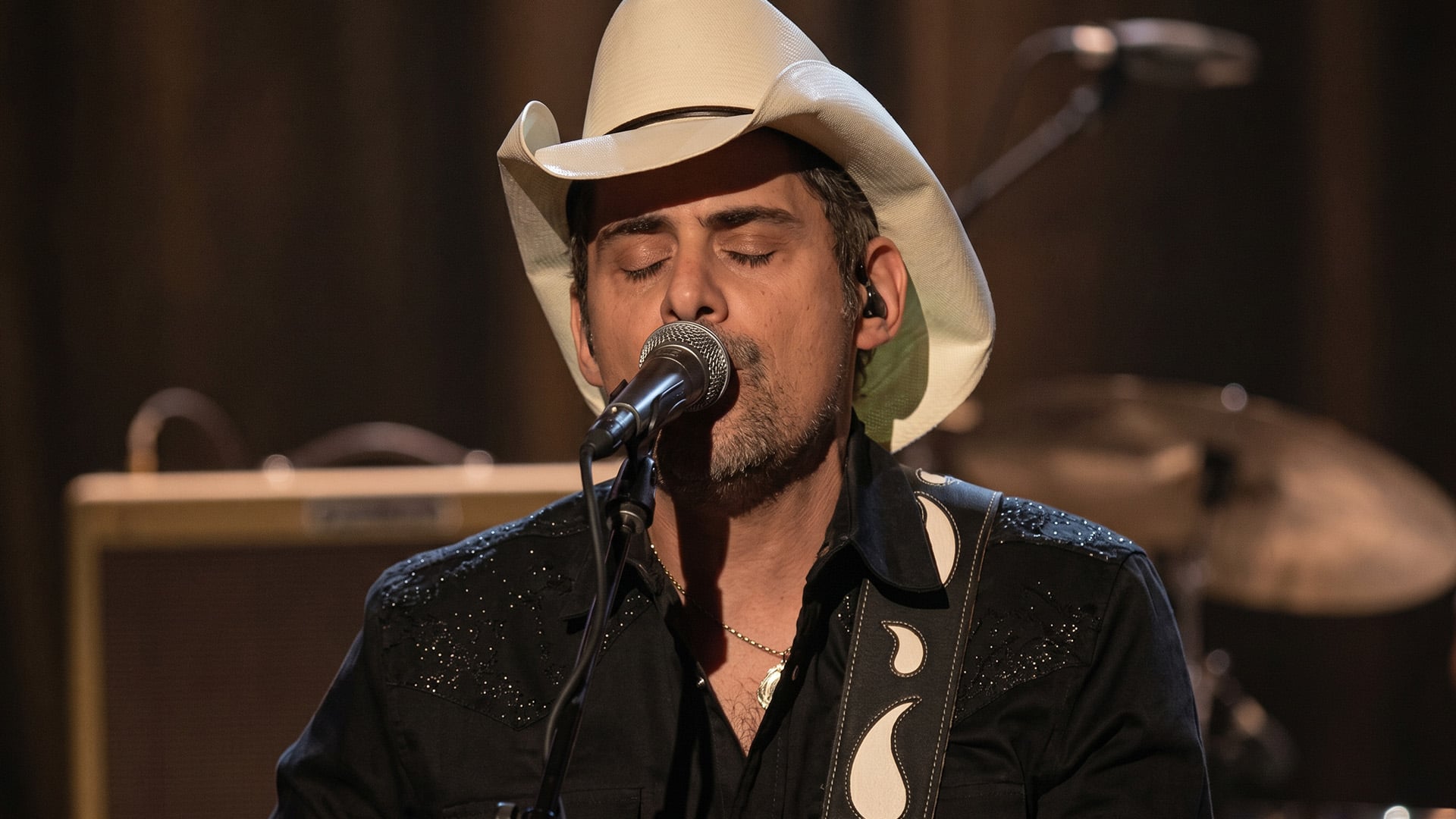 10:33 AM Brad Paisley performing on stage, shown alongside his song "He Didn't Have to Be," still the tribute that wrecks every stepdad who hears it.