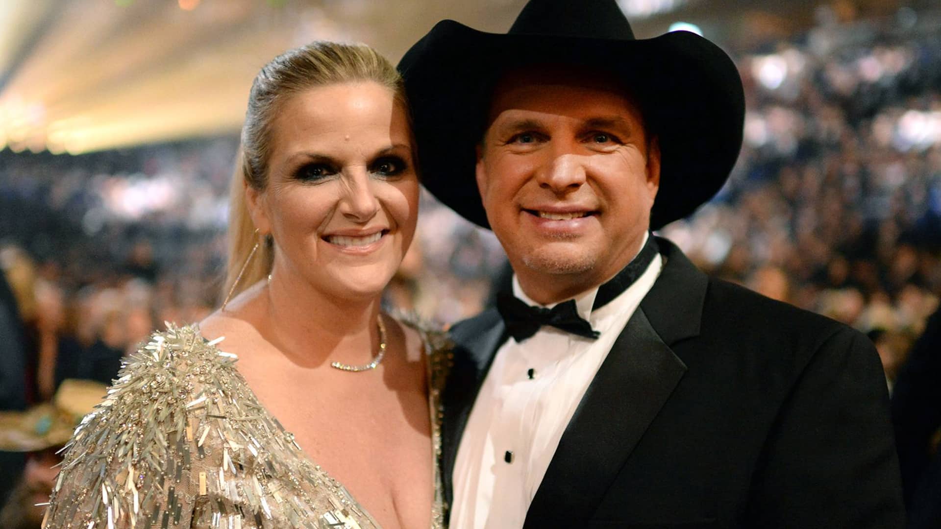 Garth Brooks and Trisha Yearwood smile together at an event, standing united amid the ongoing sexual assault lawsuit drama.