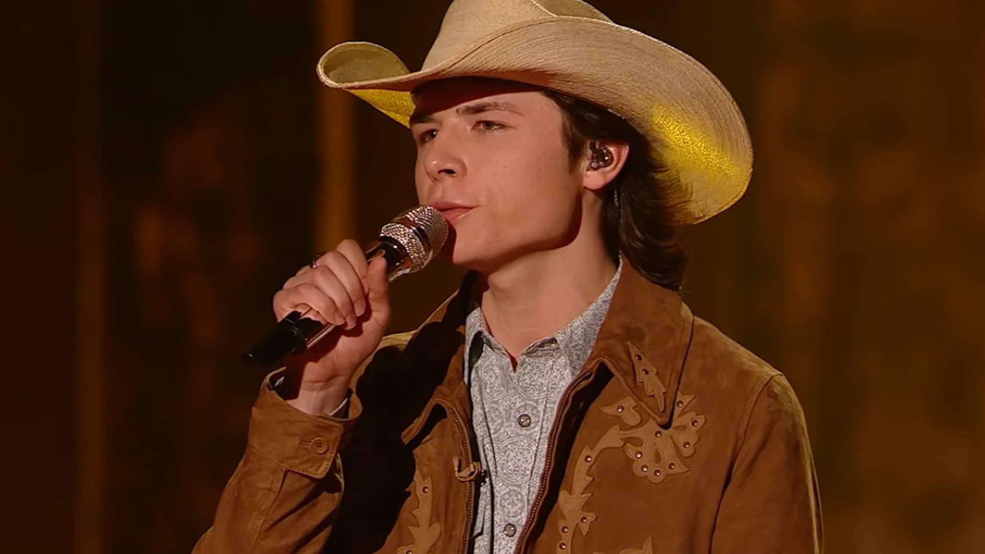 John Foster performs on American Idol after being called back following two rejections, wearing a cowboy hat and suede jacket.