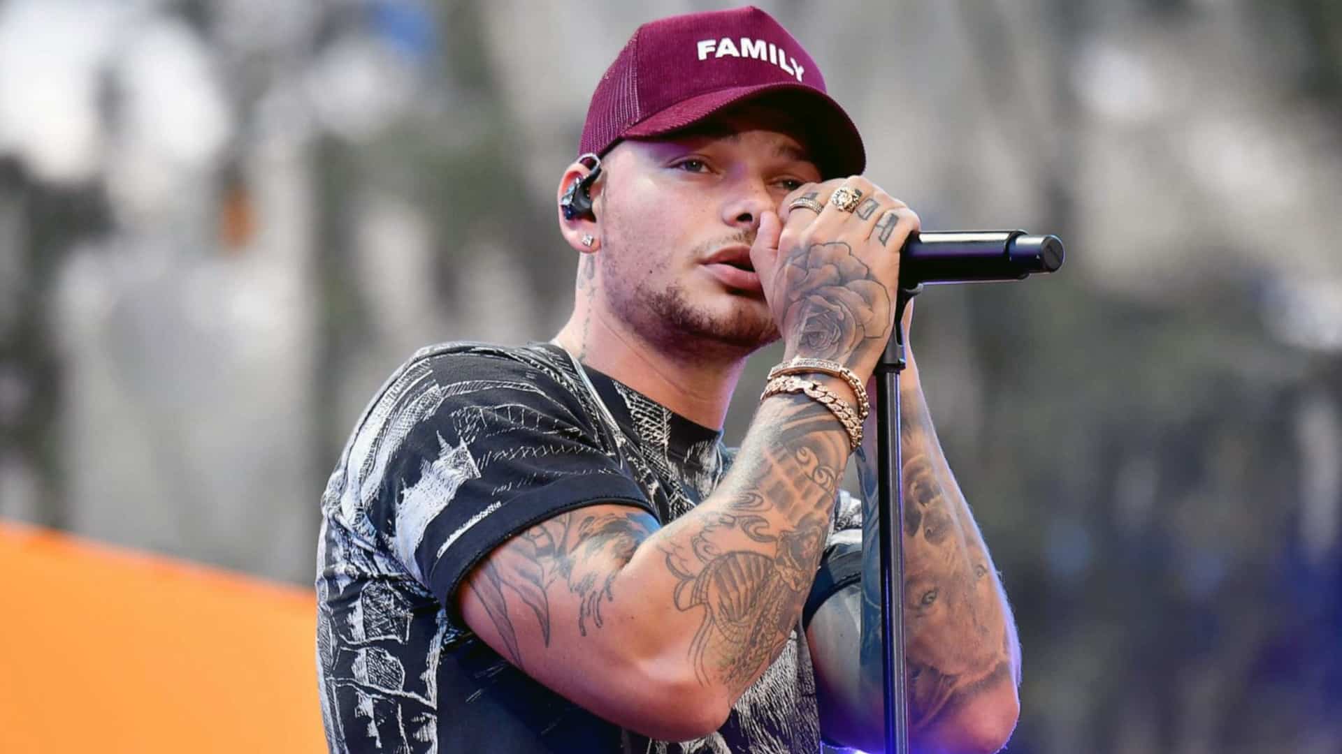 Kane Brown performs onstage wearing a “FAMILY” hat, after revealing a songwriter once refused to work with him over his skin color but came back when he got famous.