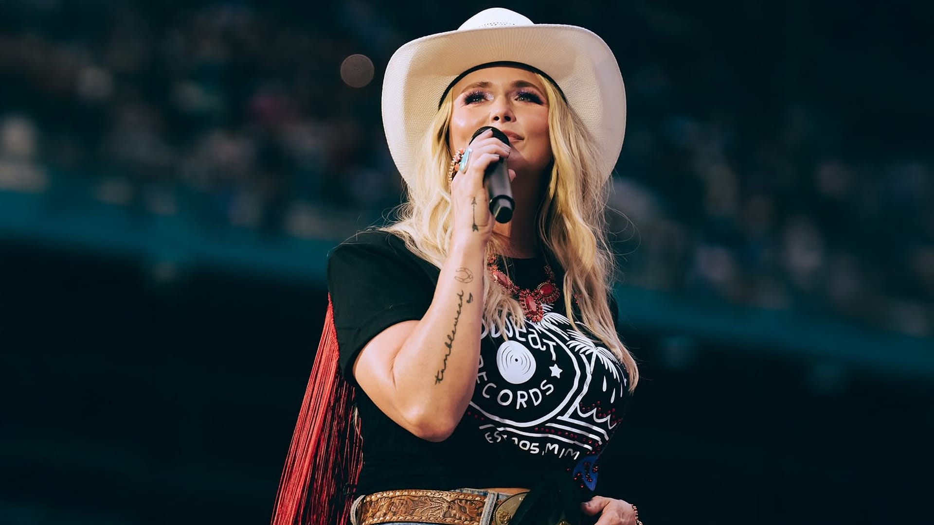 Miranda Lambert sings onstage in Miami wearing a cowboy hat and black shirt during her bittersweet tribute to her bandmate’s late father.