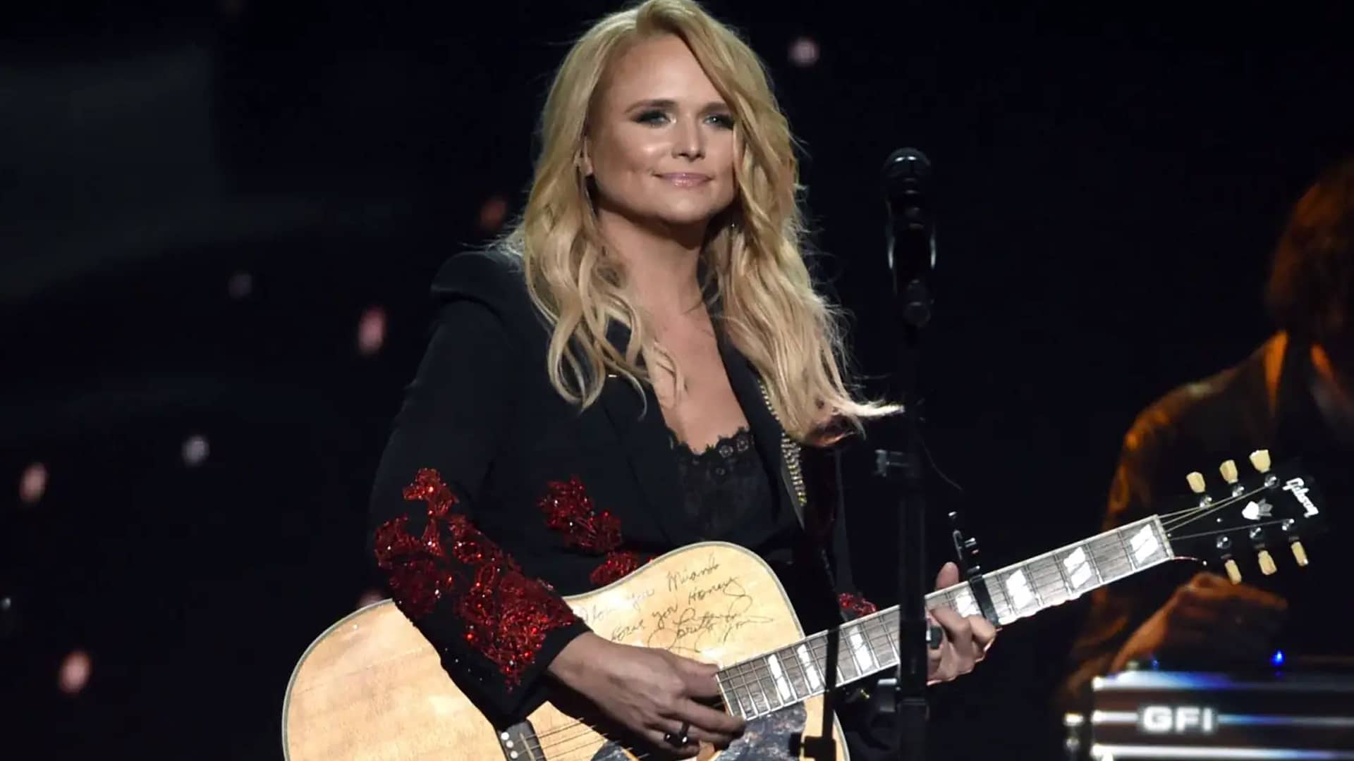 Miranda Lambert performs onstage with a signed guitar, proudly supporting her Relief for Rescues Fund that just donated over $300K to flood-impacted shelters.