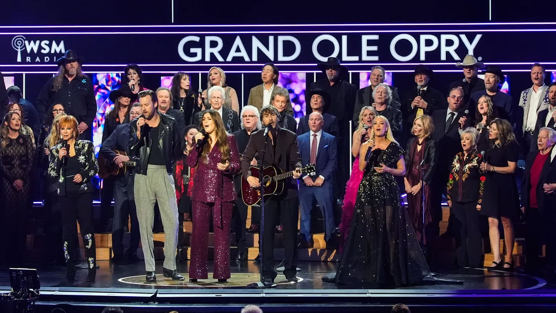 More than 50 country legends and stars join together onstage at the Grand Ole Opry’s 100th celebration for a surprise performance of “Will the Circle Be Unbroken.”