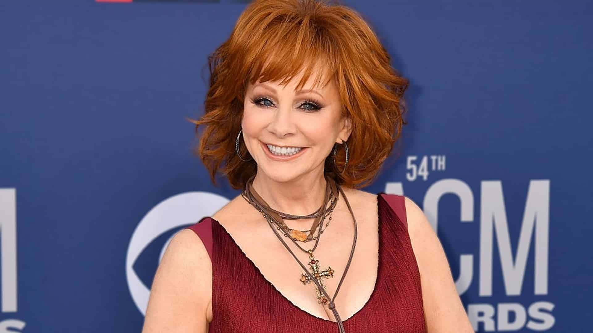 Reba McEntire, known for her fiery red hair, is pictured here in a past appearance, sparking fresh buzz in 2025 over a resurfaced photo showing her with strawberry blonde locks.