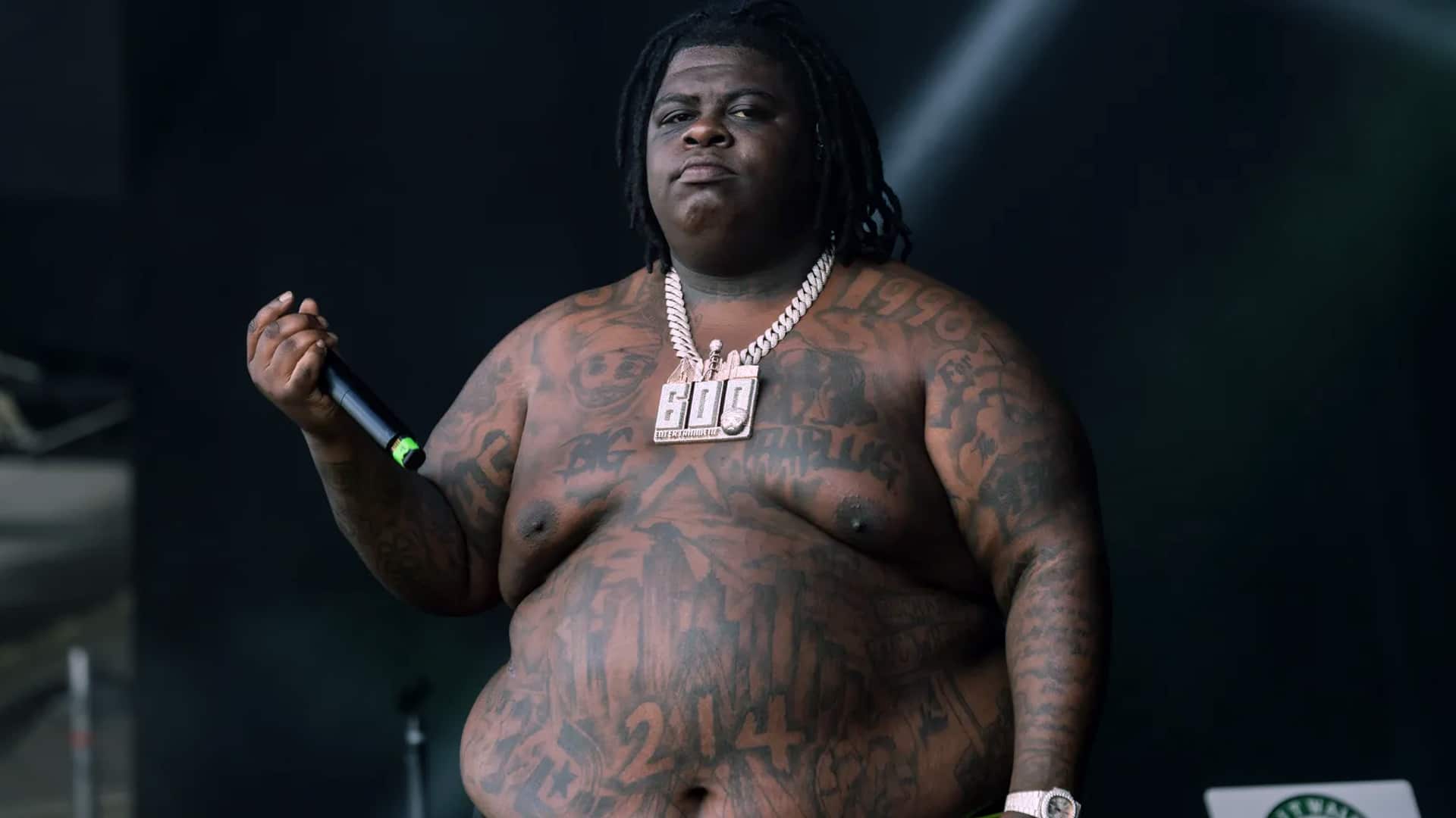Rapper BigXthaPlug onstage with bold tattoos and chain, stirring debate after admitting he doesn’t know George Strait or Willie Nelson.