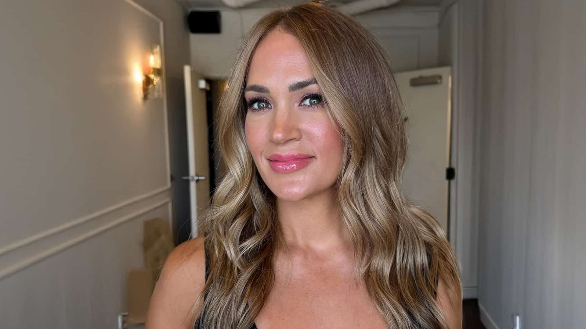 Carrie Underwood smiles with freshly revealed natural brunette hair, marking a return to her roots after 30 years of blonde.