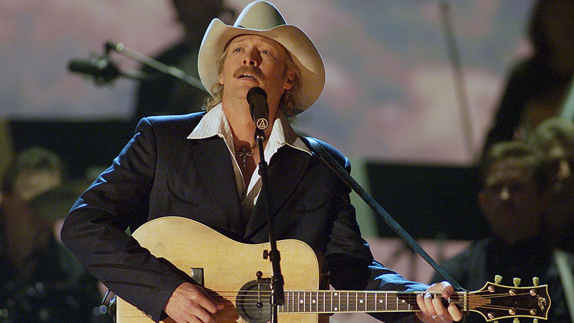 Country artist performing at the Grand Ole Opry with guitar, highlighting the tradition and modest pay for musicians on the iconic stage.