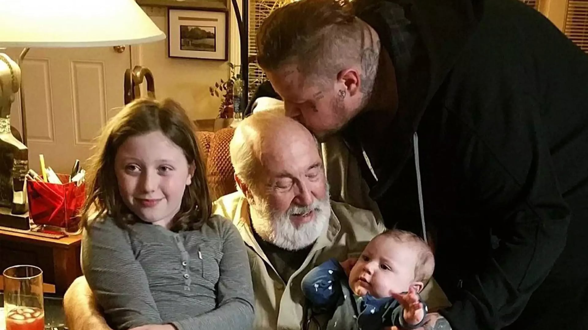 Jelly Roll kisses his father while holding his son Noah, with daughter Bailee Ann smiling nearby, showing the sweet generational bond that defines his life as a devoted dad.