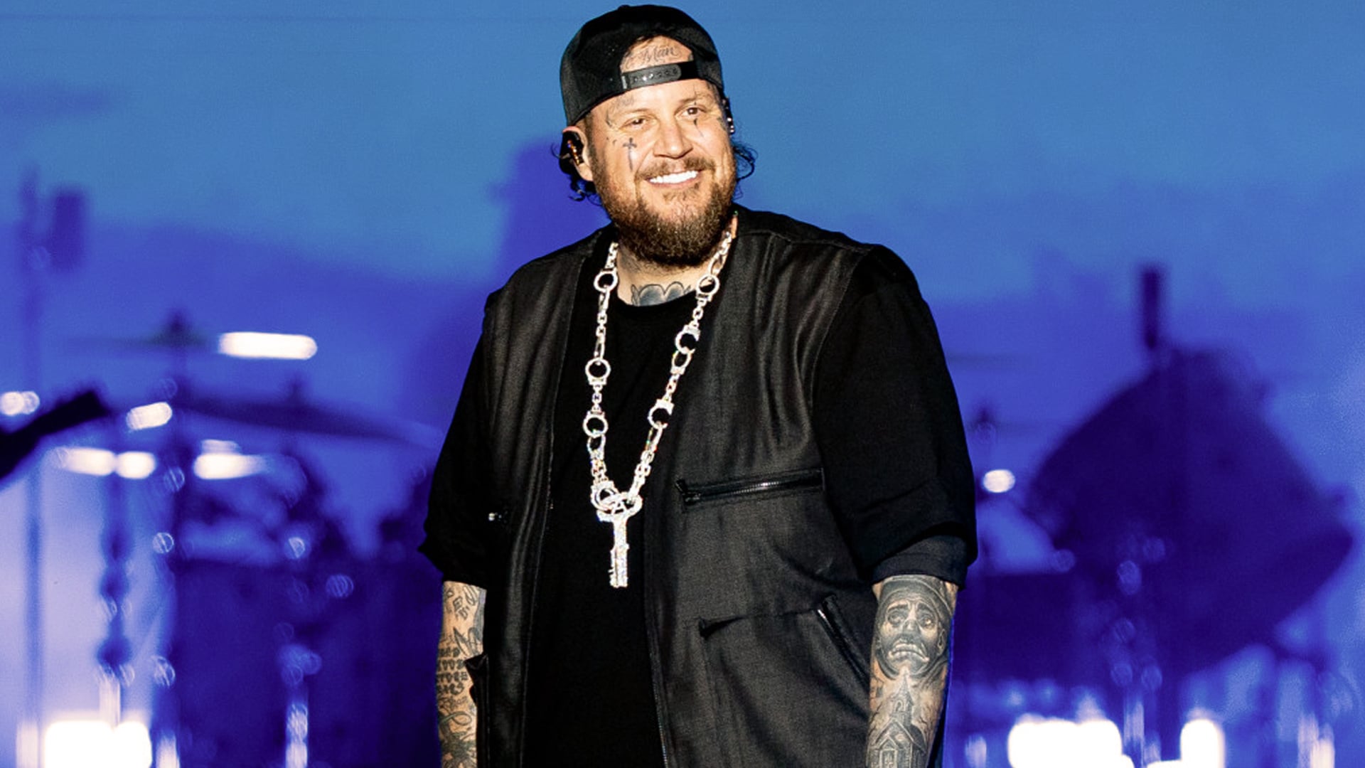 Jelly Roll smiles onstage during his tour, showing off his slimmer figure after losing nearly 200 pounds.