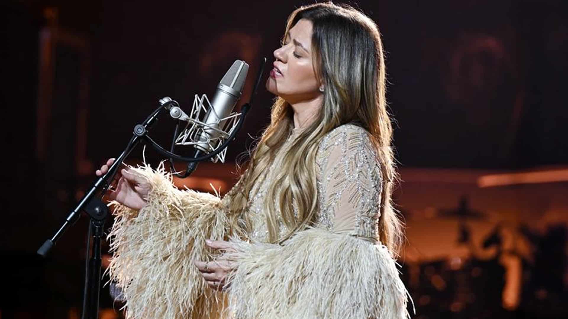 Kelly Clarkson performs with emotion, eyes closed and hand near the microphone, during a heartfelt Las Vegas rendition of "Piece by Piece" shortly before Brandon Blackstock’s death.