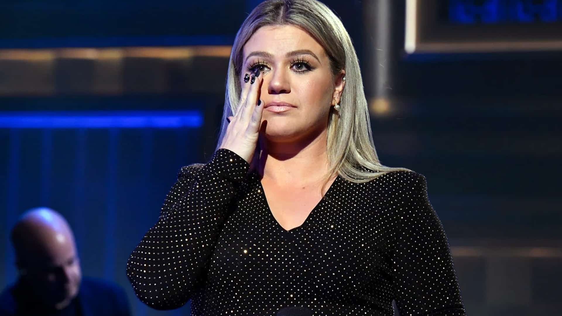 Kelly Clarkson wipes away tears on stage after show cancellations connected to the passing of her ex-husband, Brandon Blackstock.