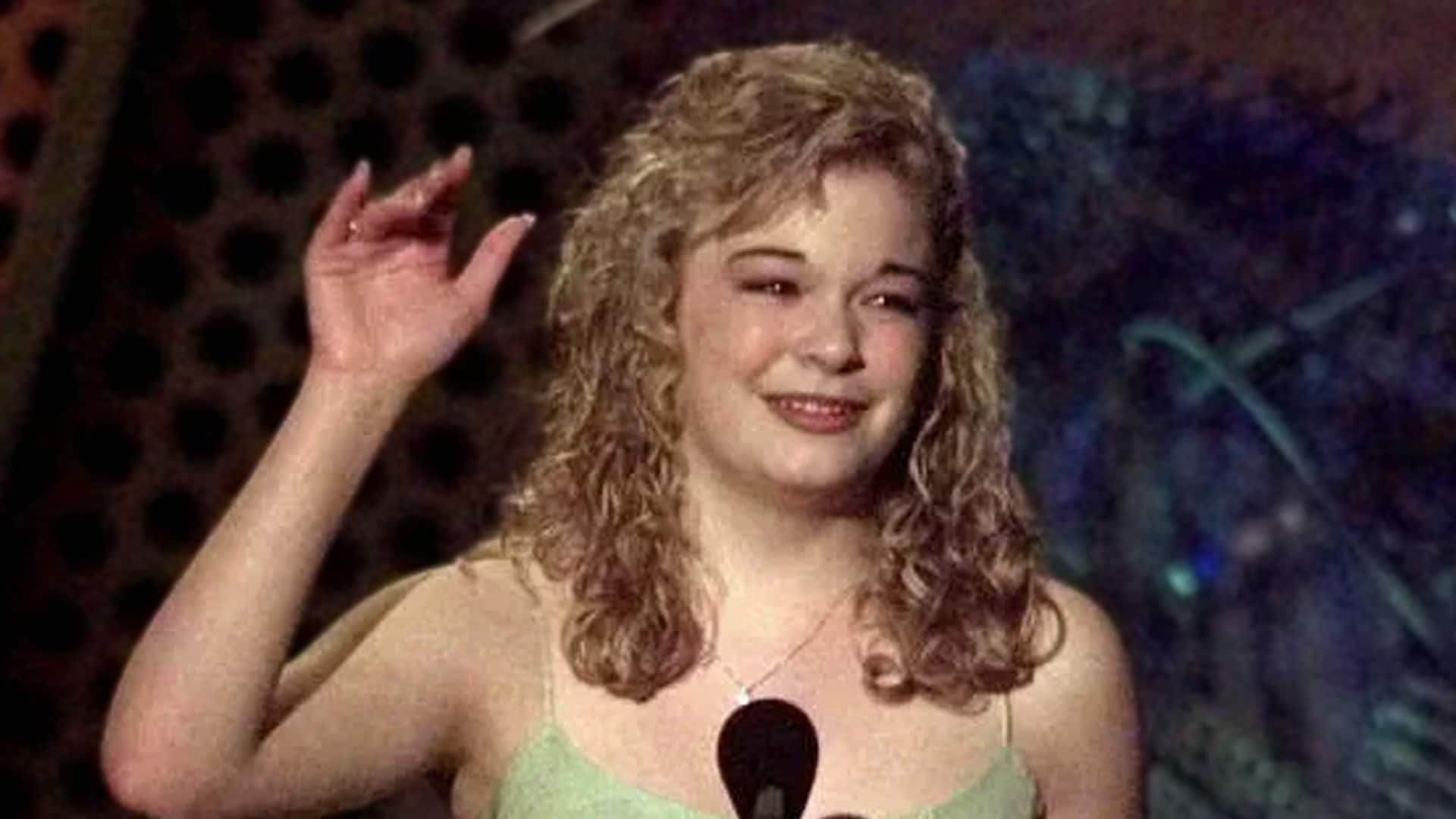 A 13-year-old LeAnn Rimes waves while accepting applause, marking her historic moment as the youngest CMA Award nominee ever.