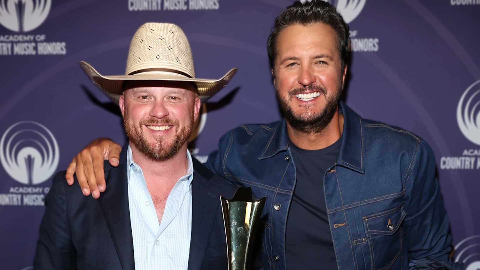 Cody Johnson holding his ACM Spirit Award alongside Luke Bryan, who honored him with a powerful cover of “‘Til You Can’t.”