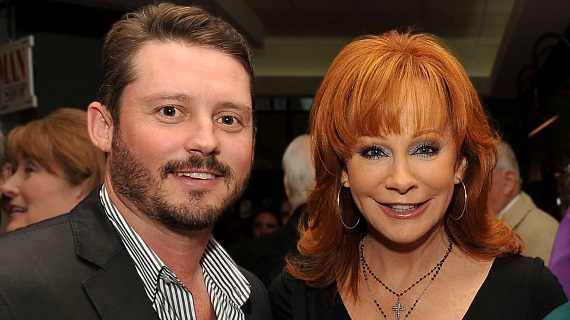 Brandon Blackstock stands beside Reba McEntire, highlighting their decades-long family connection.