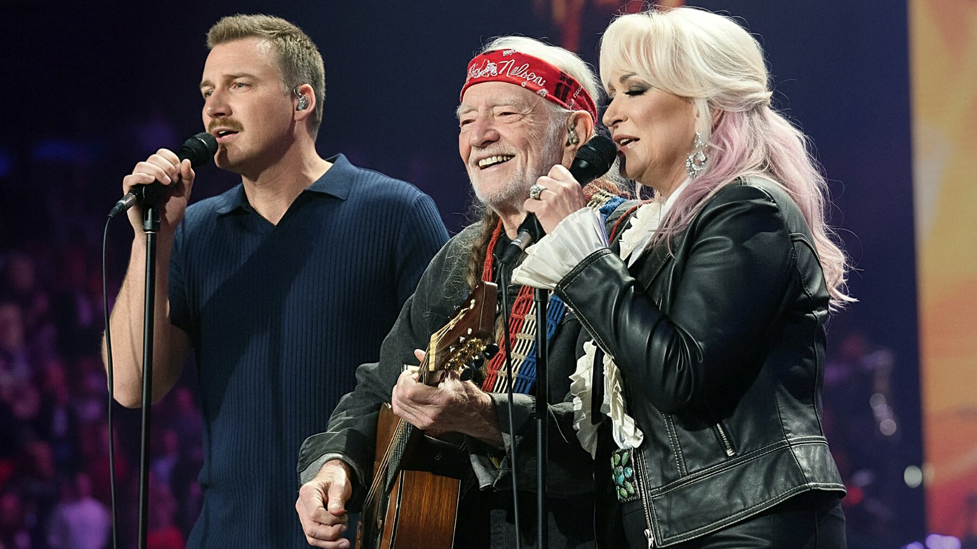 Willie Nelson performing on stage with fellow country artists, highlighting legends who still aren’t Grand Ole Opry members.