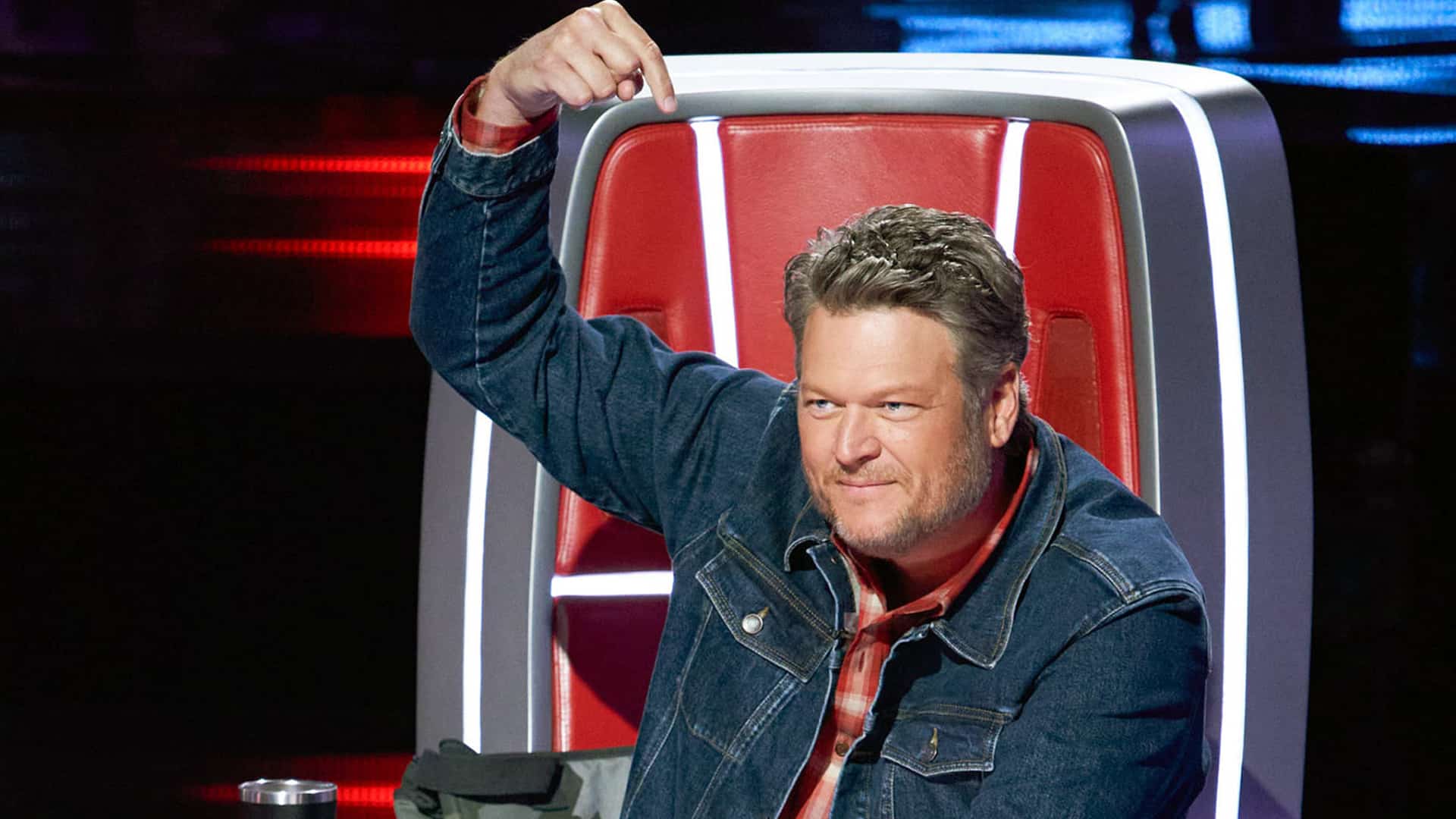 Blake Shelton gestures from The Voice coach’s chair before his 2023 exit, as fans react to his absence from the newly announced Battle of Champions.