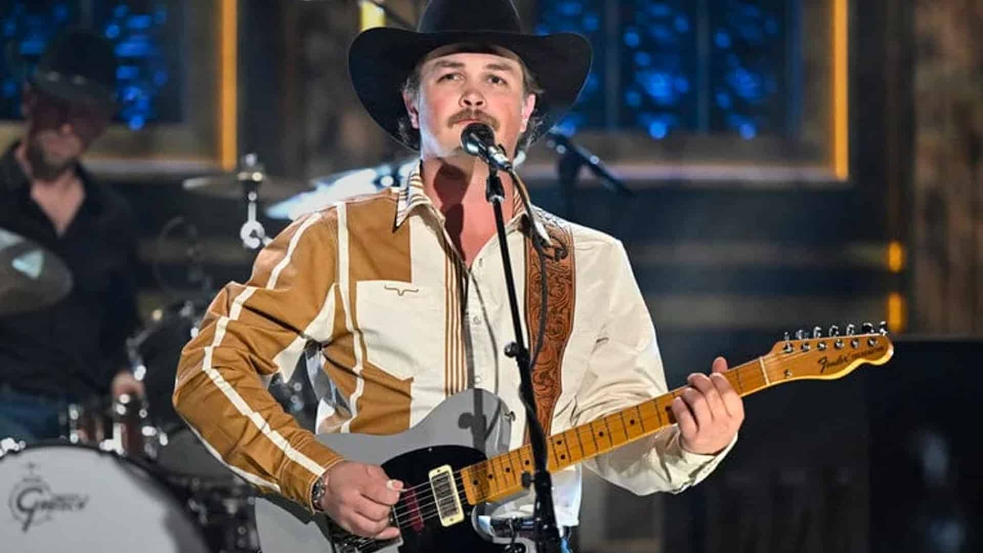 Zach Top performs in a cowboy hat and retro western shirt, keeping real country music alive with his new single "South of Sanity."