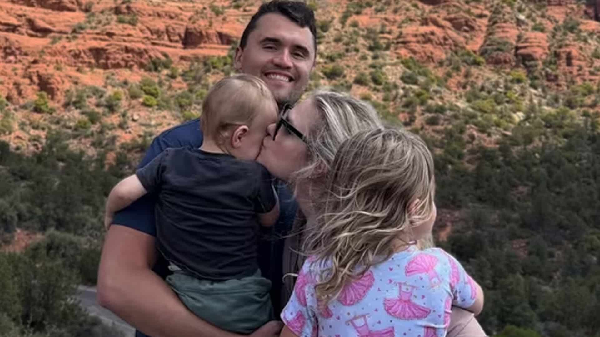 Erika Kirk kissing her young son while holding her daughter, as America rallies with millions in donations after Charlie Kirk’s death.